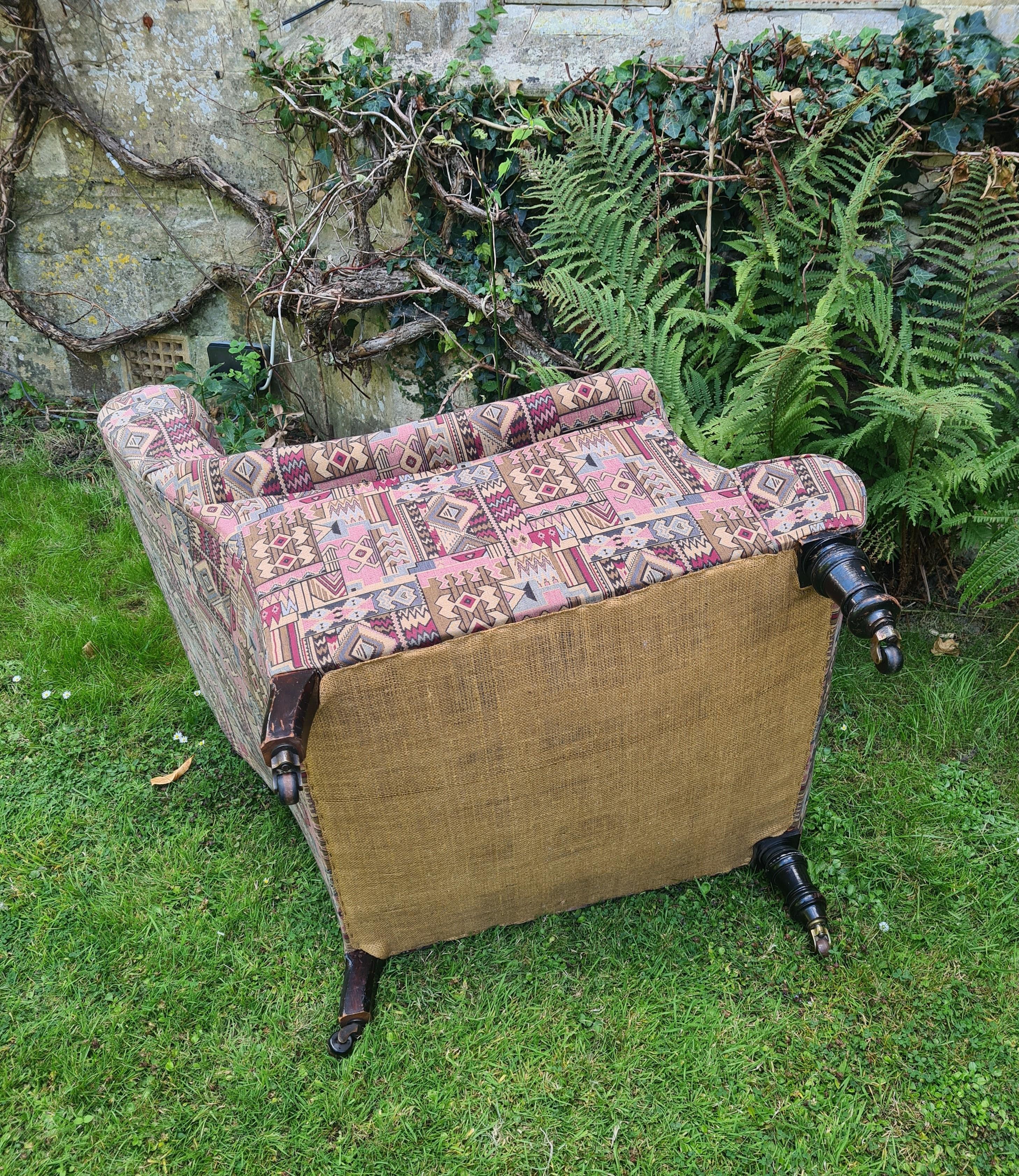 Hutton-Clarke Antiques takes great pleasure in presenting an exquisite Victorian upholstered easy armchair, dating back to circa 1890. This remarkable piece stands gracefully on turned legs, accentuated by its original castors, showcasing the