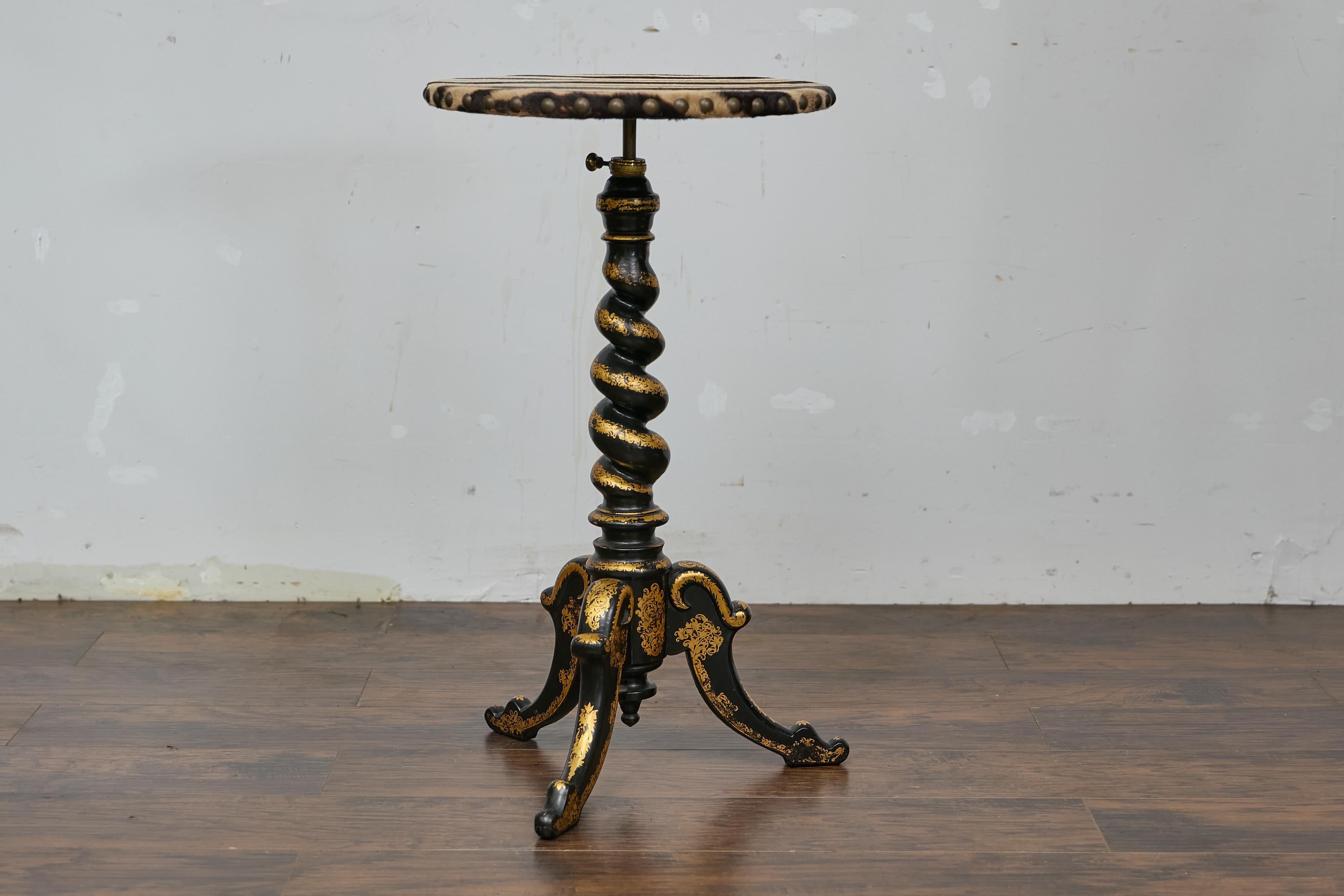 An English Victorian period barley Twist accent table from the 19th century with ebonized and gilt finish. This elegant 19th-century English accent table brings an exotic and timeless charm to any home. With its ebonized spiral base and lavish