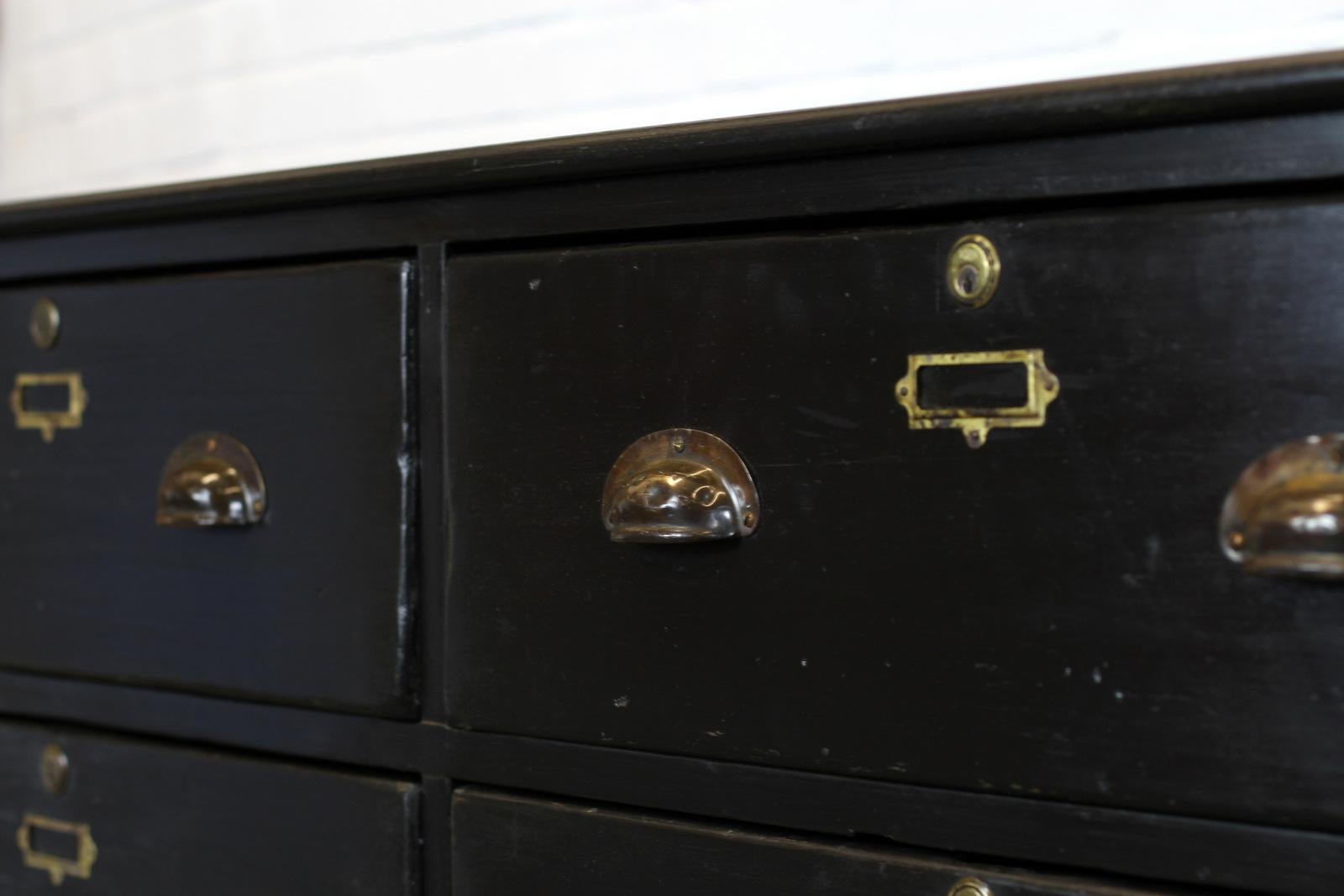 English ebonized tailors drawers, circa 1870s.

- Oak top and sides
- Pitch Pine drawers
- Rolled copper handles with brass card holders
- 9 large drawers
- Hand cut dovetail drawer joints
- English, circa 1870s
- Measures: 273cm long x 71cm