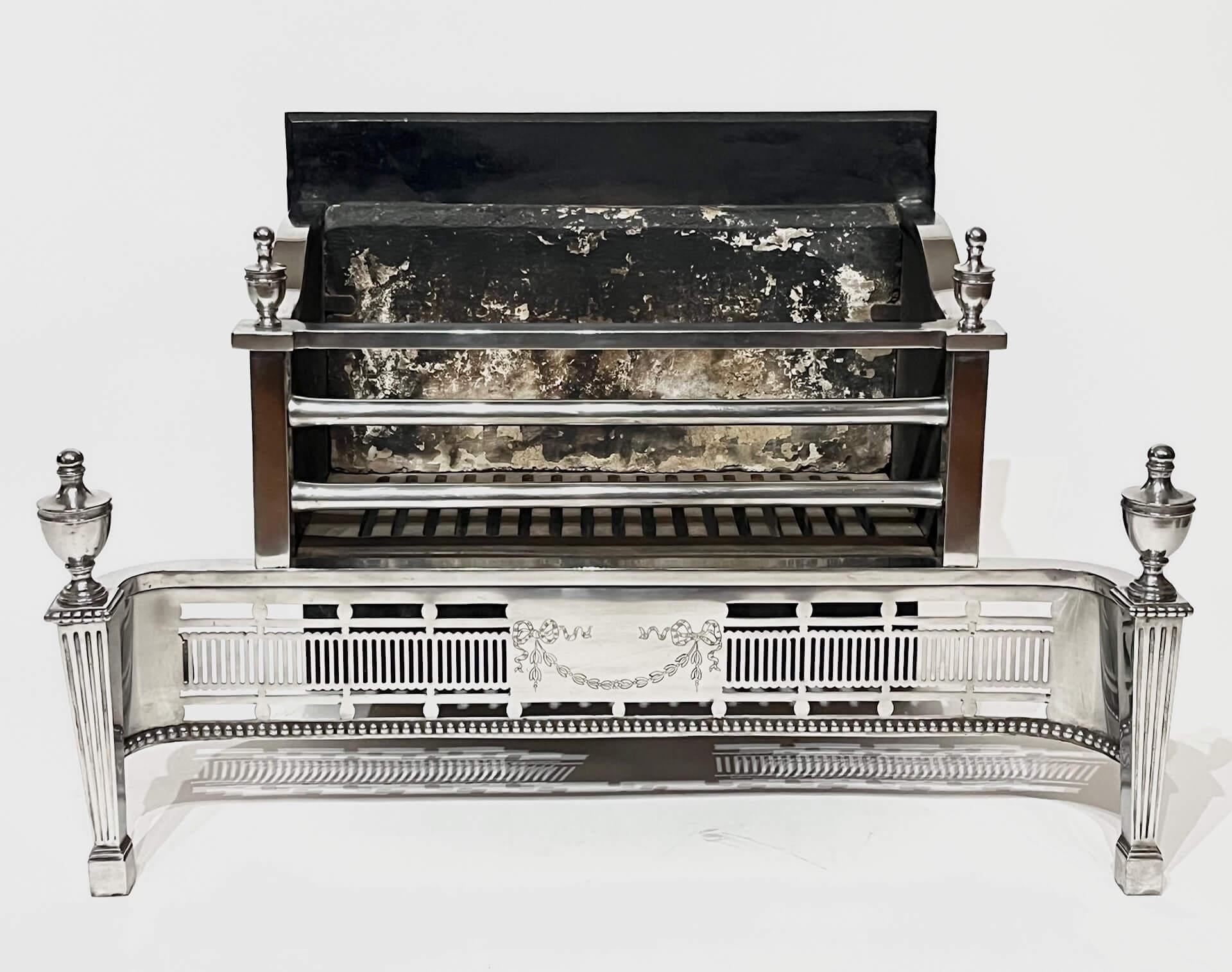 Elegante griglia inglese edoardiana del 1905 circa, in acciaio lucido e ferro, in stile georgiano di Robert Adam, di forma rettangolare, con il retro del fuoco in ghisa e l'isolante originale in terracotta, cestello con fondo in ferro scanalato e