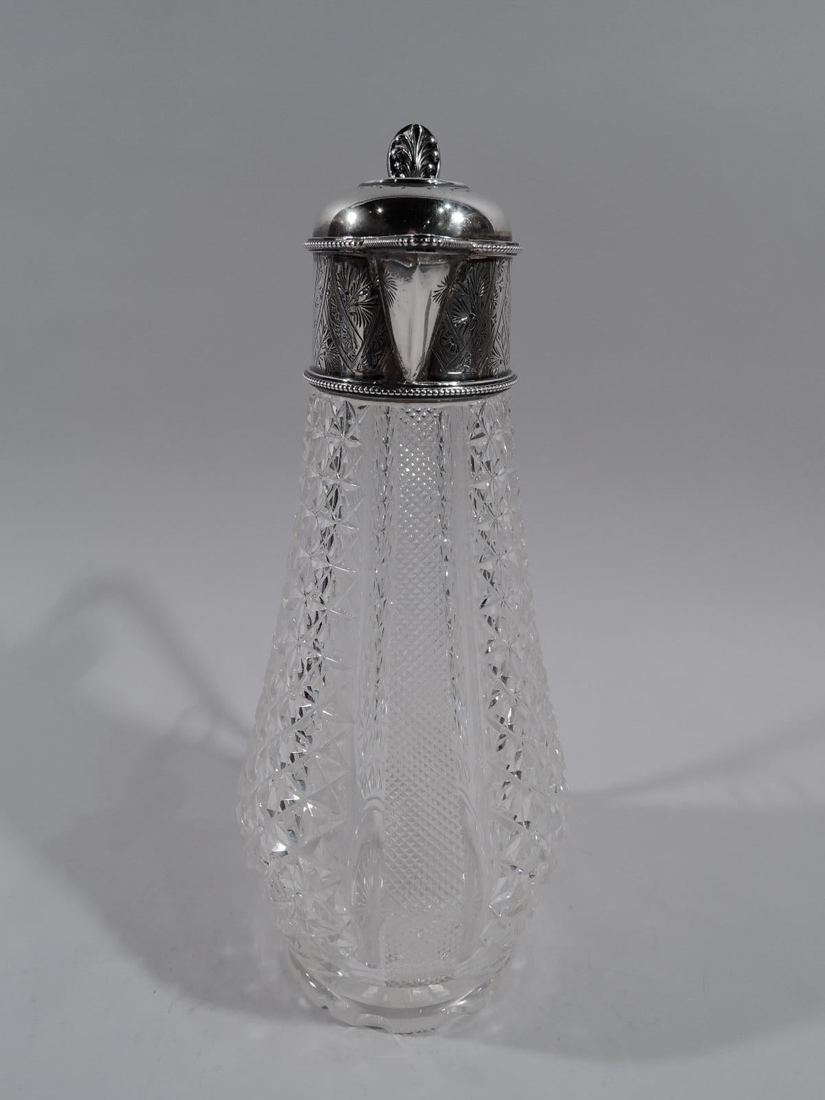 Edwardian Aesthetic decanter. Made by Walker & Hall in Sheffield in 1901. Ovoid clear glass bowl with cut vertical diaper ornament and plain flutes. Round and notched foot. Sterling silver collar with v-spout and hinged and domed cover with leaf