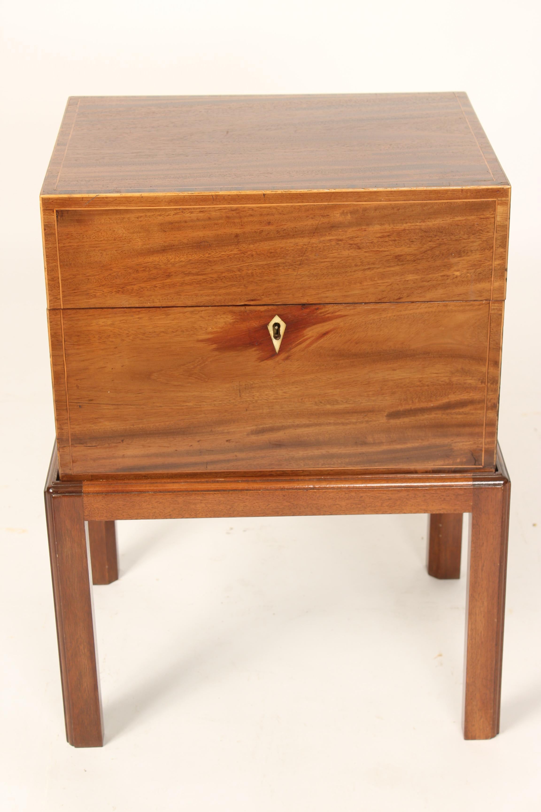 English Edwardian box (circa 1910) on a late 20th century stand. Nicely figured mahogany, cross banded top, front, sides and back with a bone shield shaped escutcheon and brass handles on the sides. The lock stamped secure lever.