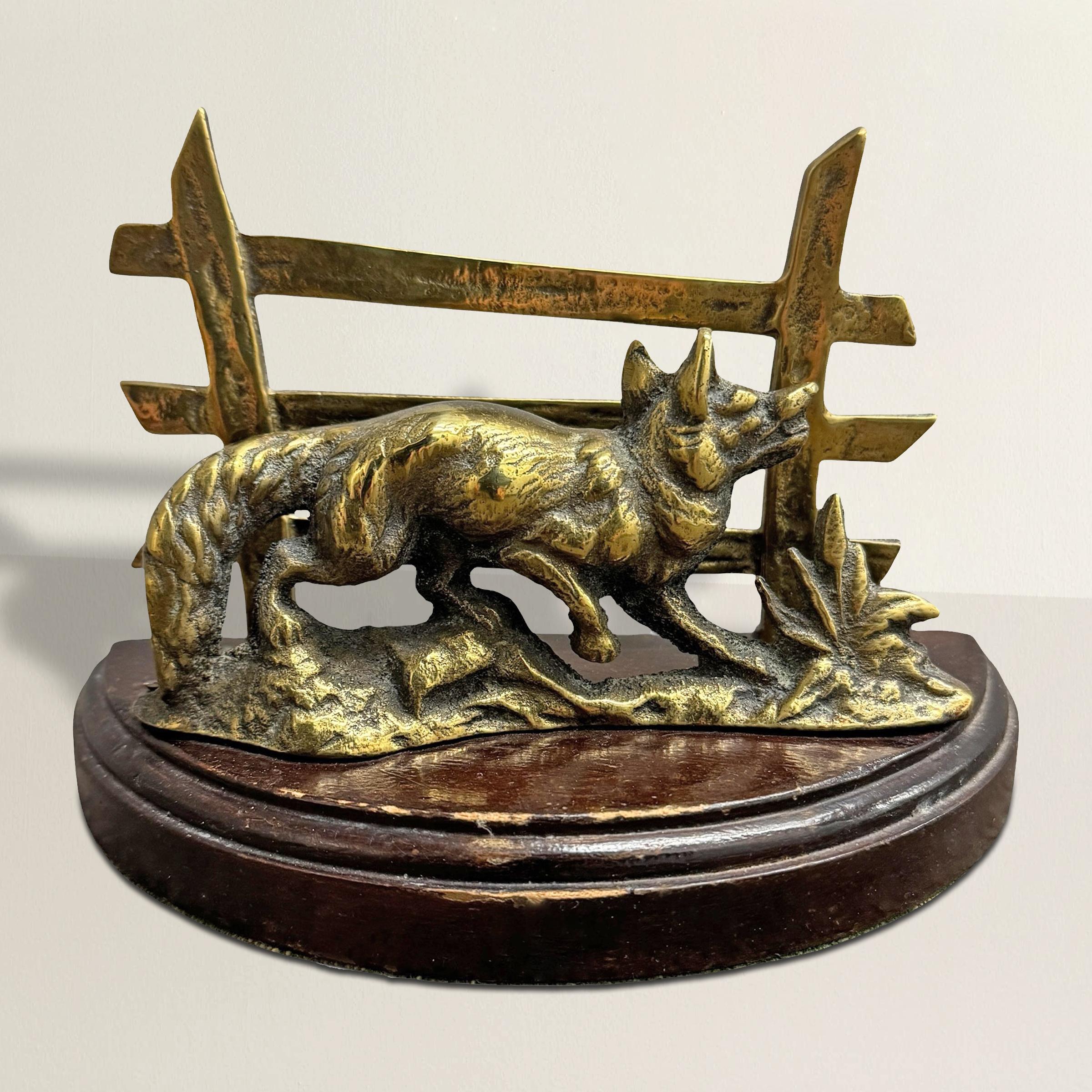 This early 20th-century English Edwardian letter holder combines utility with charm, showcasing a beautifully cast brass fox mid-leap, its form brimming with energy and detail. Framed by graceful grasses and a brass fence, the scene captures the