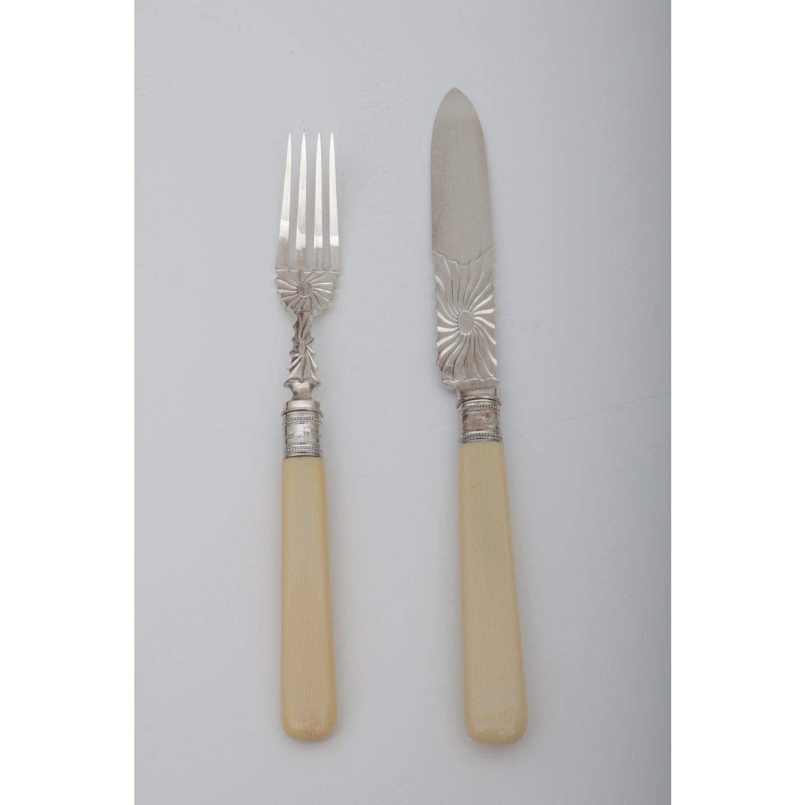 This stylish twelve (12) piece place setting dessert set dates to the early 1900s-1920s and is the Edwardian taste. The set is composed of twelve knives and twelve forks that are fabricated in silver plate with celloide handles in an oakwood