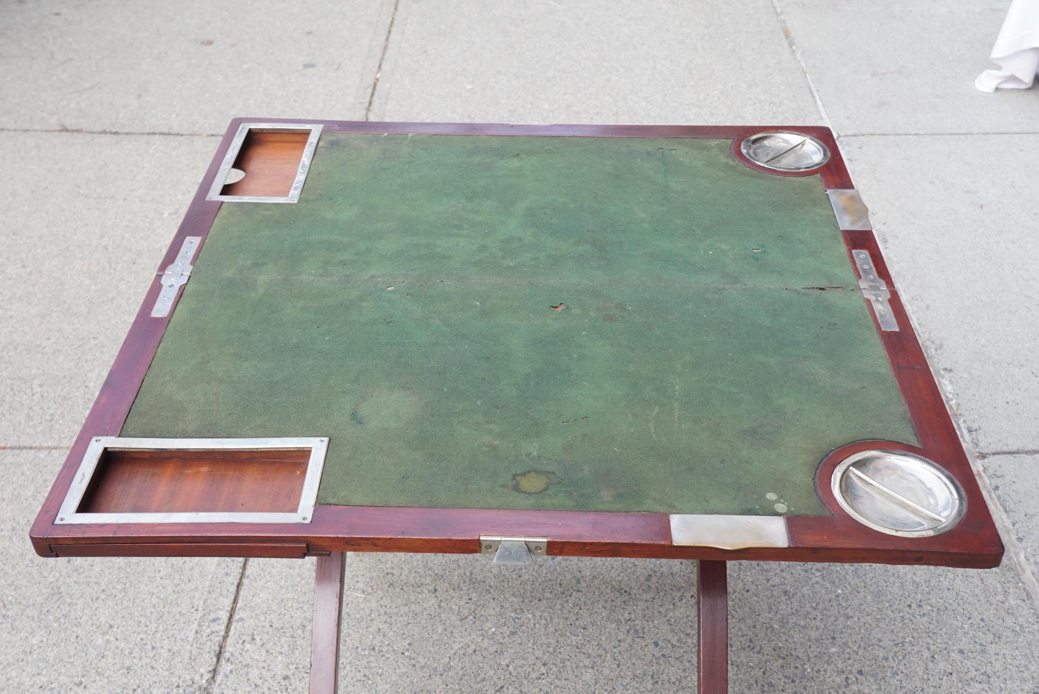 Dieser schöne und ungewöhnliche Spieltisch ist von seltener Form, ca. 1900 und 1910, ist aus Mahagoni und Deal Secondaries. Die Messingbeschläge sind alle verchromt, was sonst nur bei Bootszubehör der Fall ist. Der Tisch lässt sich in geschlossenem