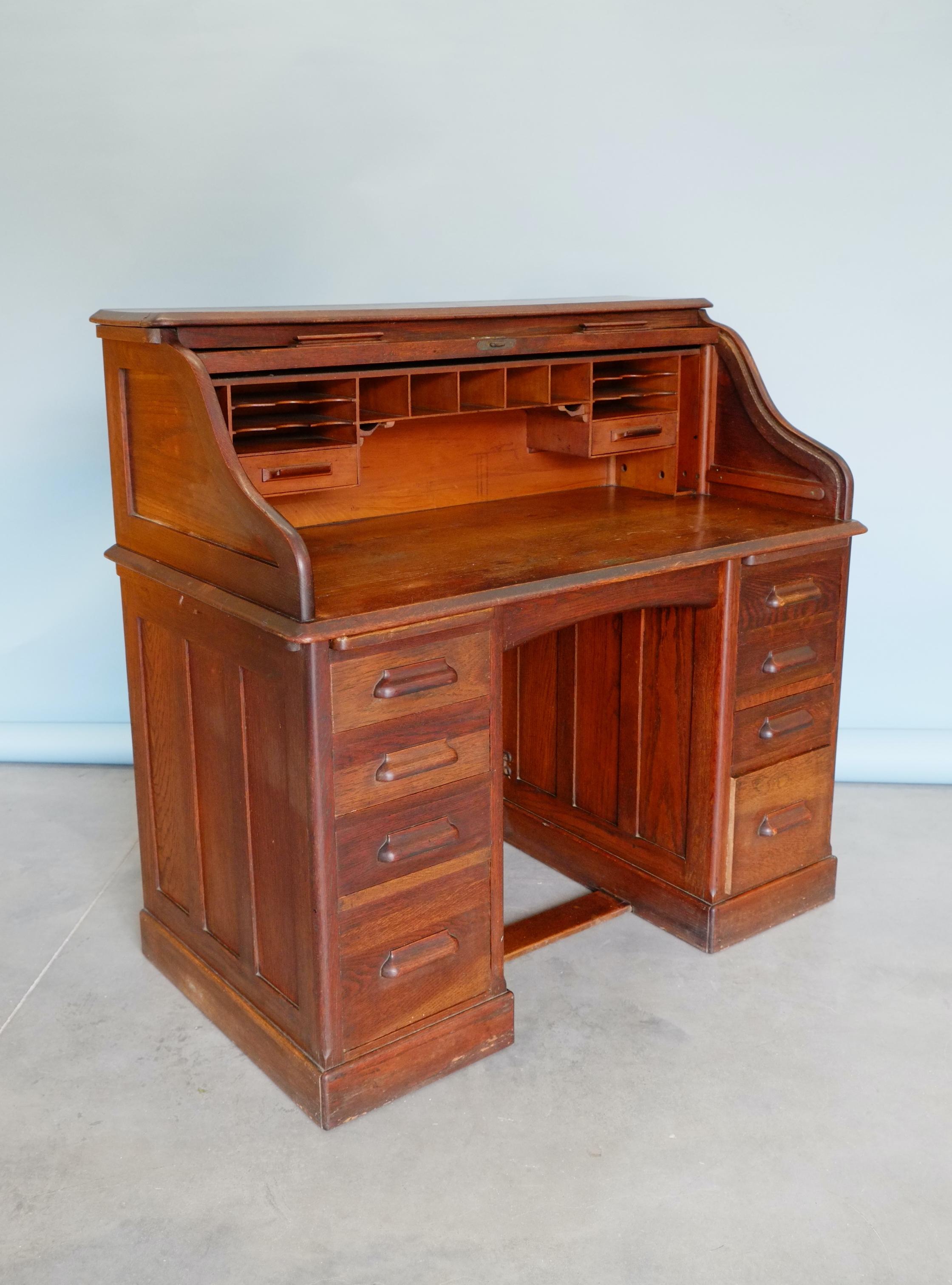 Beautiful English Edwardian double pedestal, roll top oak desk. Handsomely made by ‘HLL’ Harris Lebus, London ‘Entirely English Make’. Classic English solid oak desk from the early 1900's. Fitted with so many drawers, writing trays and pigeon holes