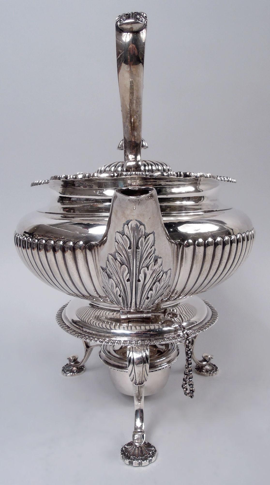 Edwardian Georgian sterling silver kettle on stand. Made by Elkington & Co Ltd in Birmingham in 1904. Bellied bowl with half-gadrooning. Cover hinged and gadrooned. Leaf-capped scroll handle mounted to shells and leaves. Upward-tapering leaf-wrapped