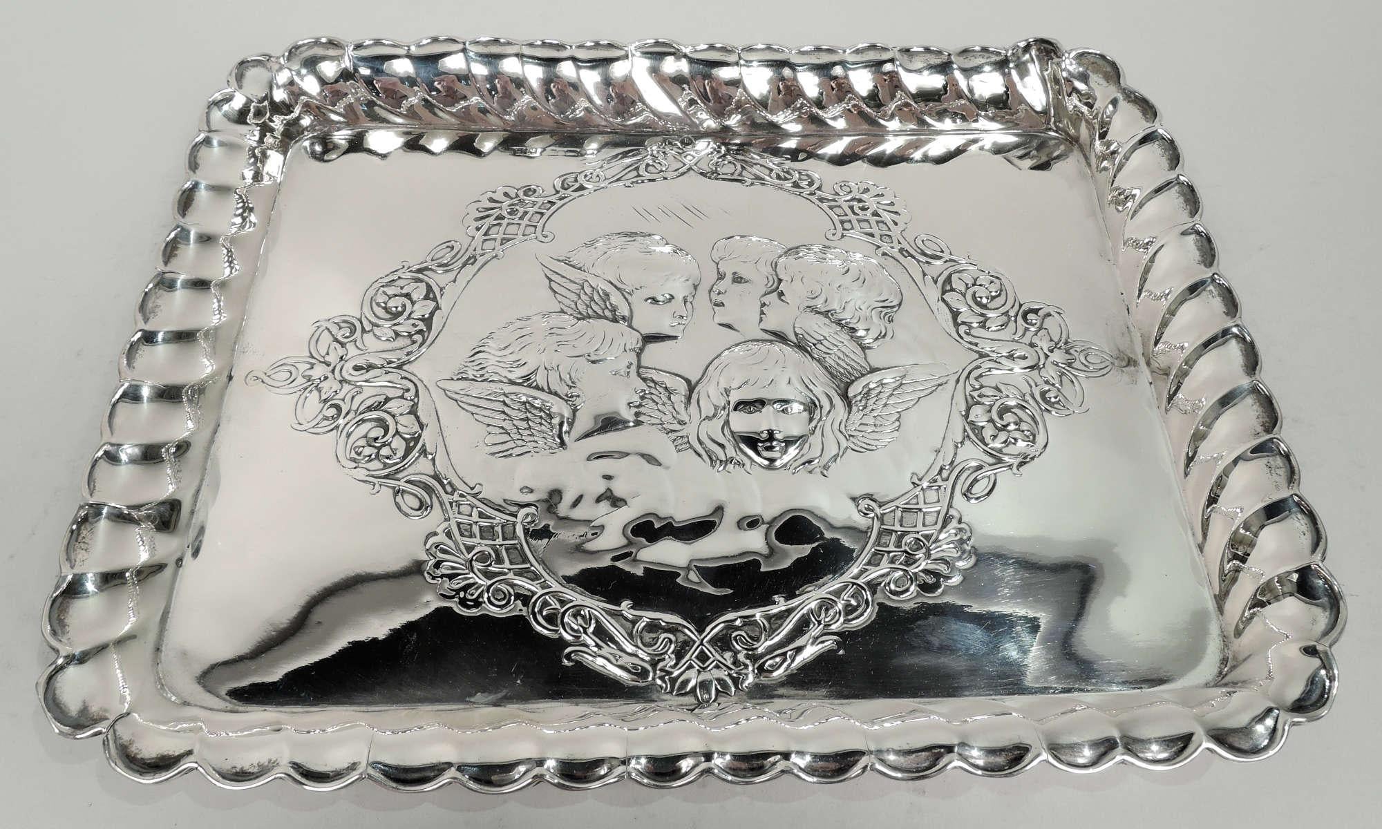 Edwardian Georgian sterling silver tray. Made by Henry Matthews in Birmingham in 1903. Rectangular with twisted fluted sides and flared and scalloped rim. Well has embossed angel’s heads after Joshua Reynolds’ painting from the late 1780s; scroll
