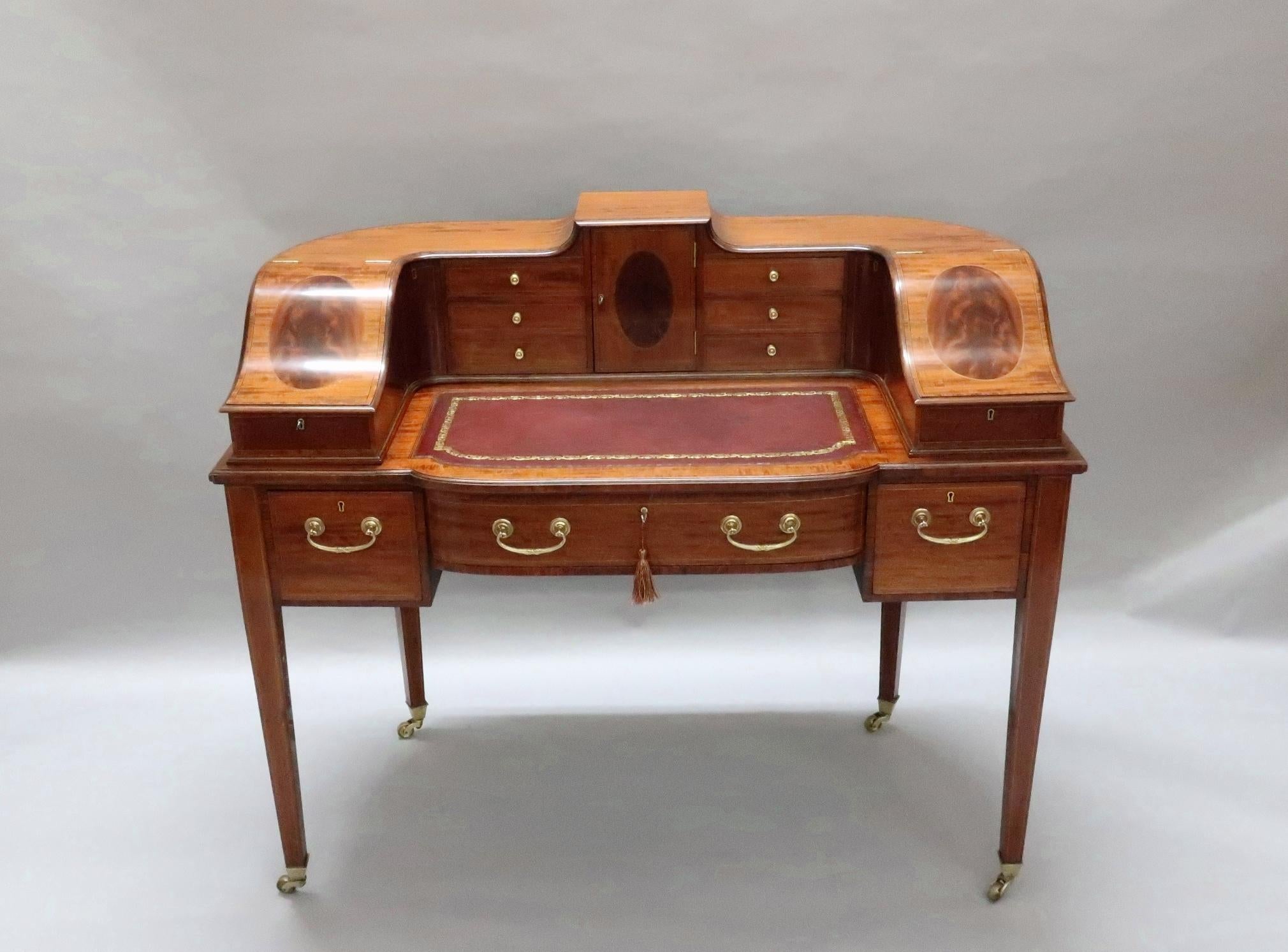 A superb quality Edwardian mahogany and kingwood crossbanded sweeping superstructure Carlton house desk with figured oval panels edged with ebony and boxwood stringing. The desk has an extendable maroon leather writing surface with letter