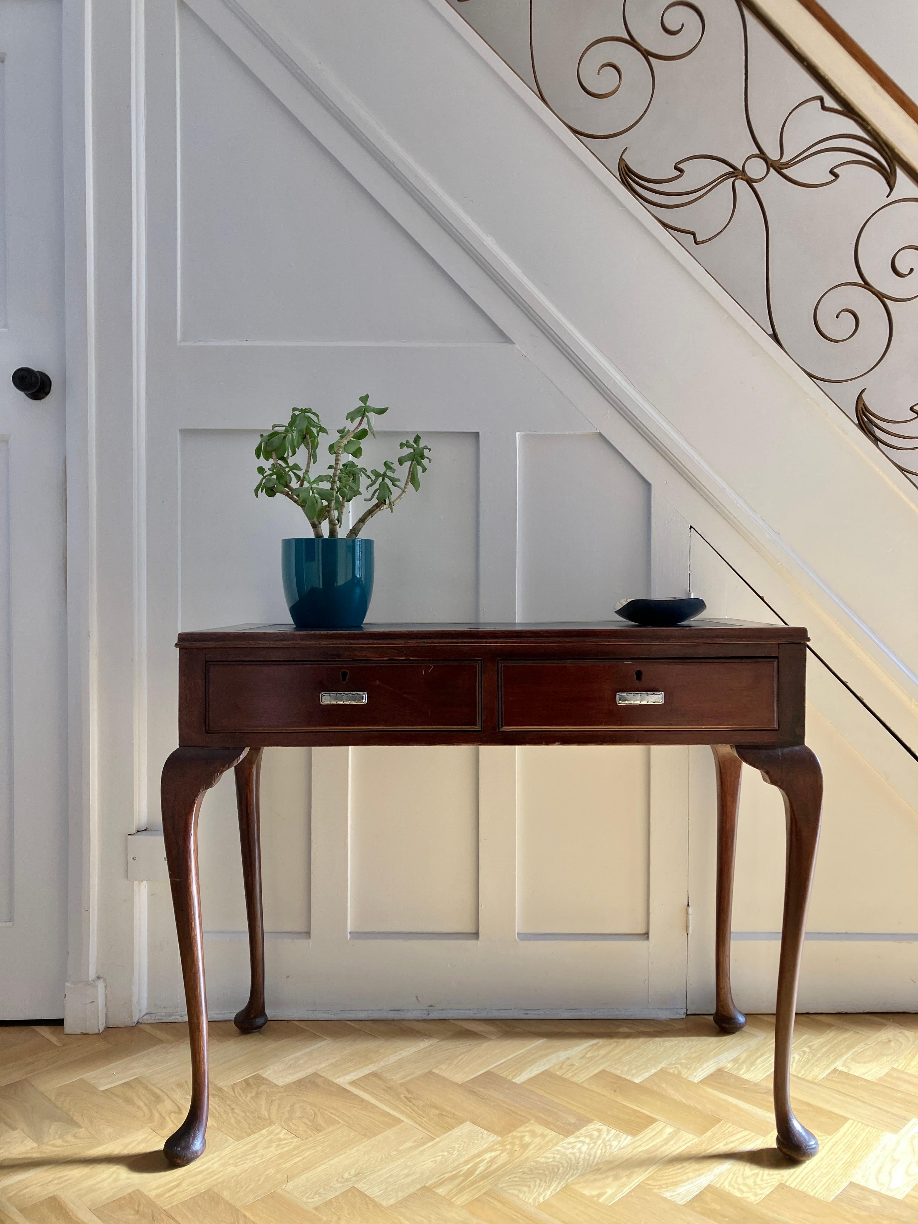 A lovely antique Mahogany console table. The console table has two small drawers at the front with silver handles, and cabriole legs with round feet.  The table top has an attractive blue center cover. This English console table is Edwardian and has