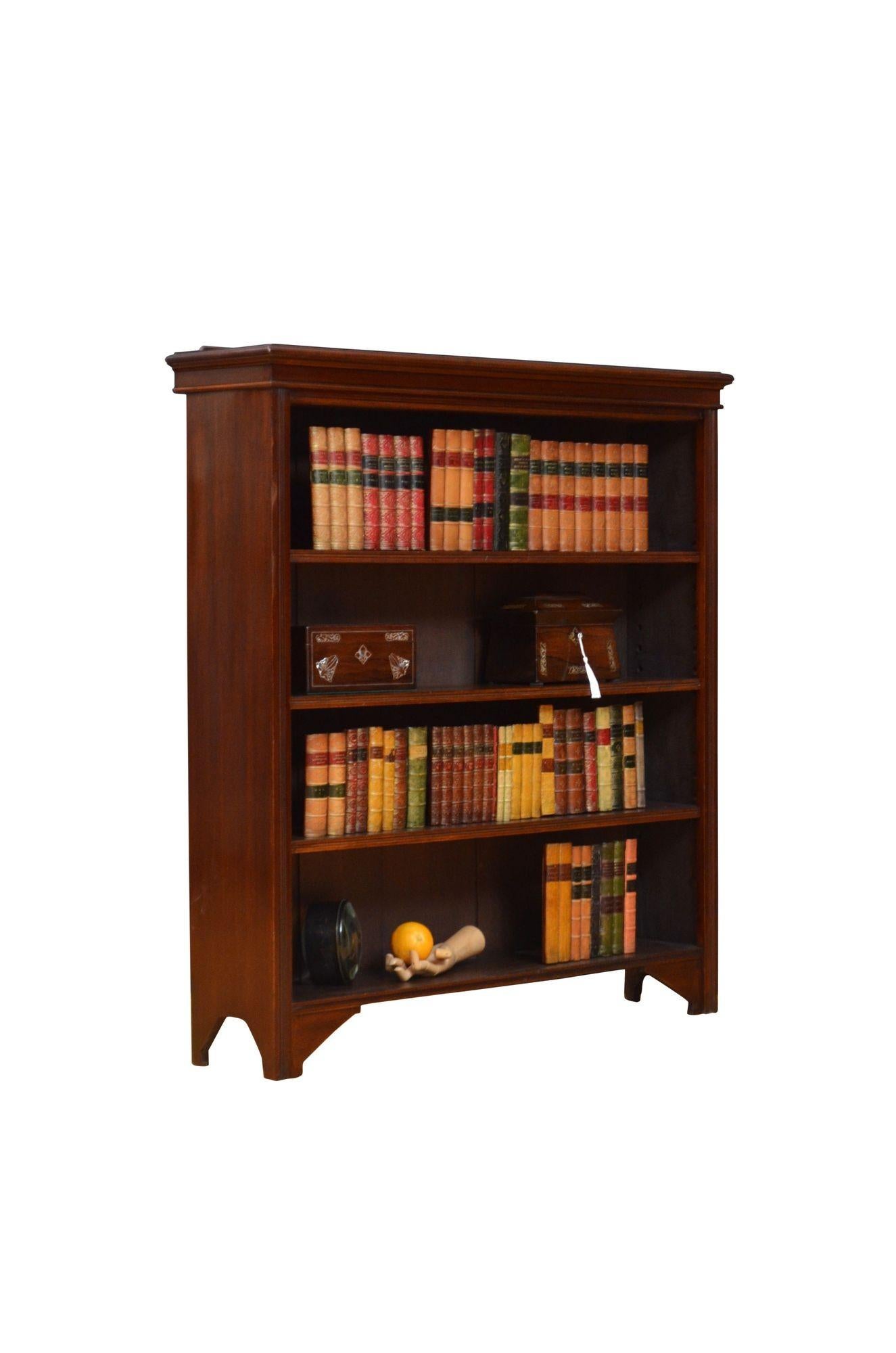K0626 Librería abierta de caoba eduardiana, con tablero sobreelevado con borde moldurado sobre tres estantes regulables en altura flanqueados por montantes de caña, todo ello apoyado sobre pies de ménsula. Esta librería antigua conserva su pátina