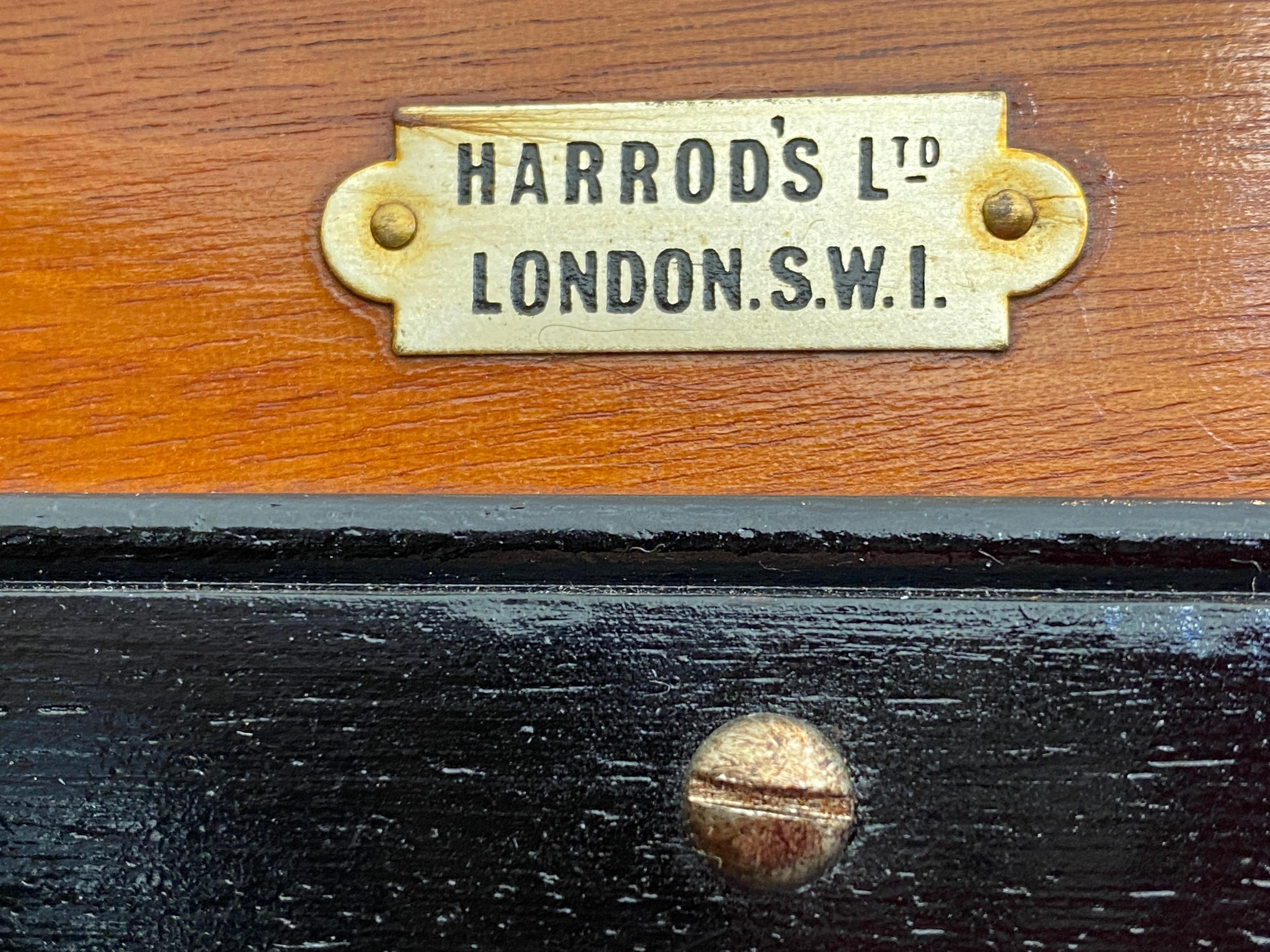 This stylish and practical mahogany wardrobe dates to the English Edwardian period and was retailed by Harrod's Ltd of London. The piece if fitted with various compartments, drawers and openings, for all of a gentlemans needs for dress. And on the