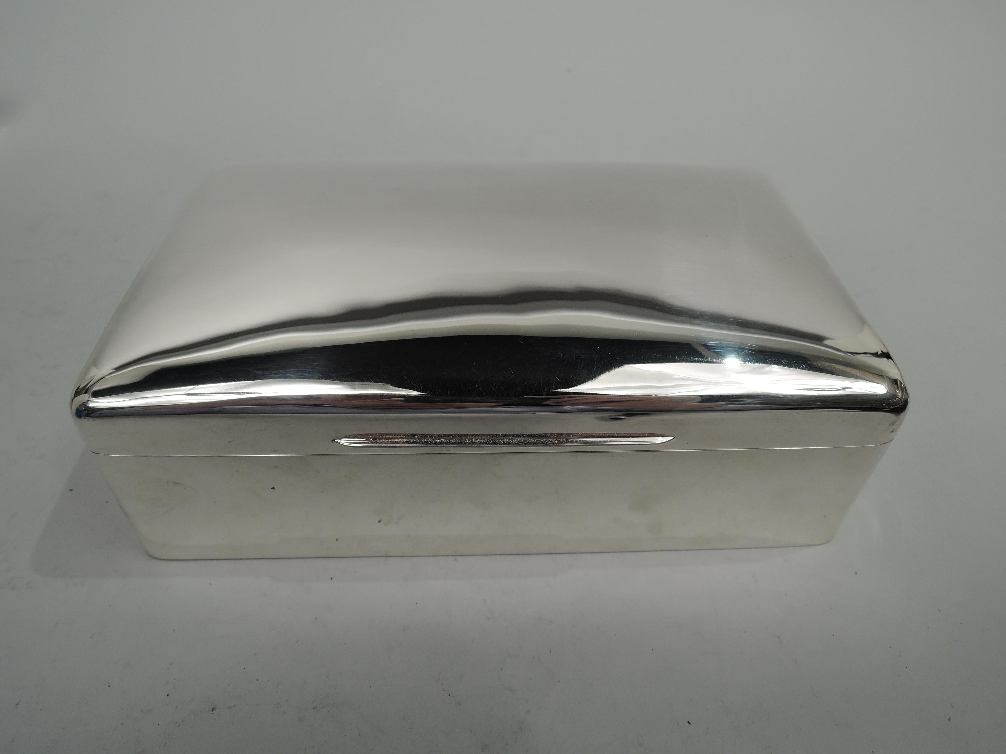 Edwardian Modern sterling silver box. Made by William Comyns in London in 1905. Rectangular with straight sides and curved corners. Cover hinged with gently curved top and tapering tab. Box interior cedar lined. Open leather-lined bottom. Cover