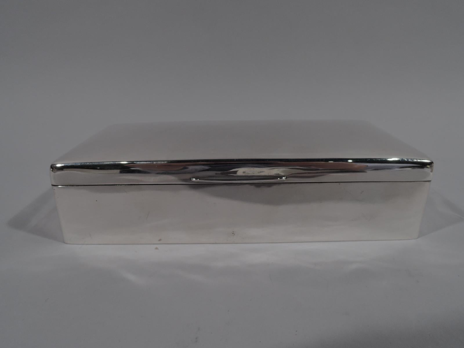 Edwardian Modern sterling silver box. Made by Arthur & John Zimmerman in Birmingham in 1904. Rectangular with straight sides and curved corners. Cover hinged and gently curved with curved tab. Box and cover interior cedar lined and partitioned.
