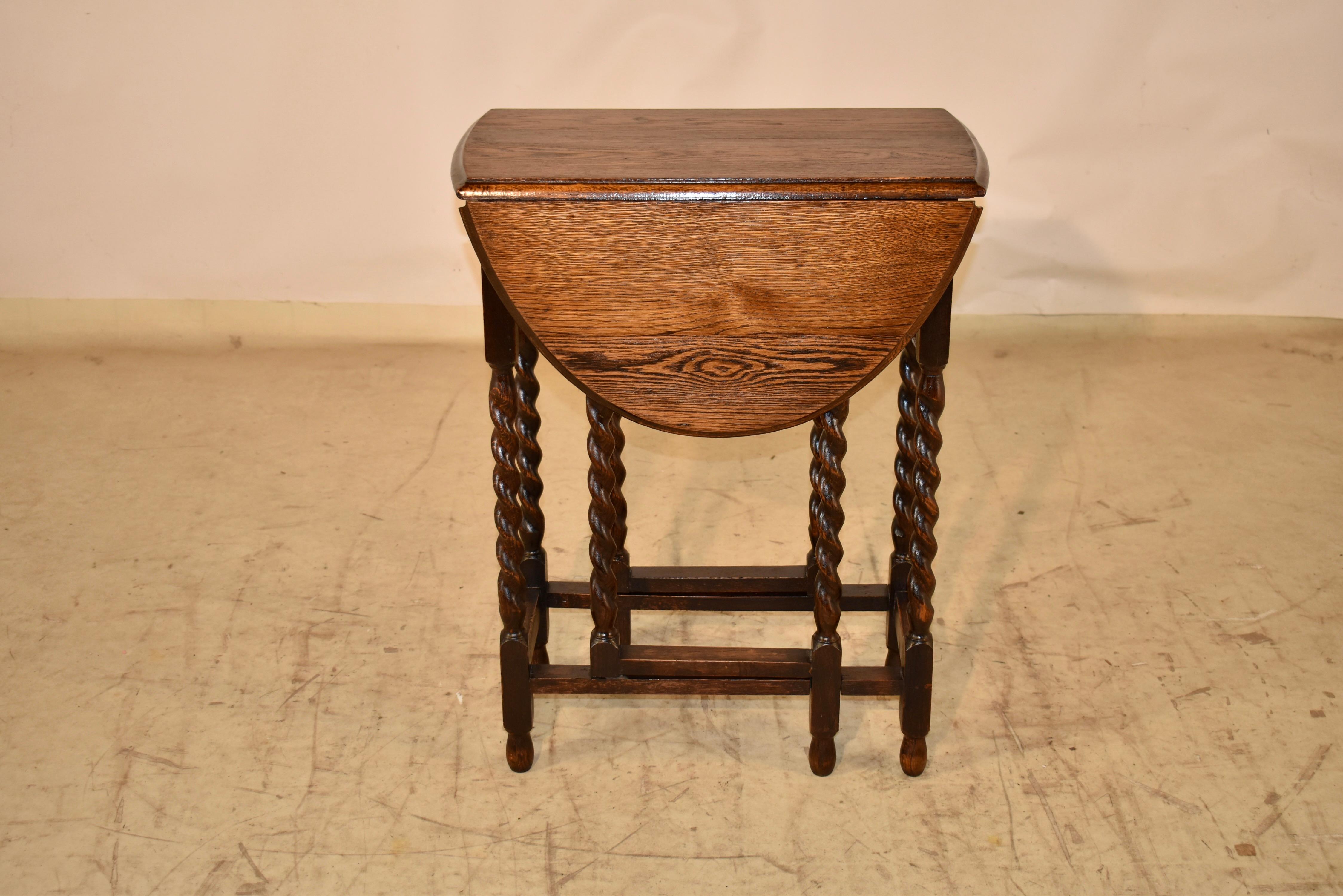 Circa 1900 Edwardian oak gate leg table from England.  The top has a beveled edge and is nicely grained.  When the lease are up and the top is open, the top measures 34.5 inches in width.  The top is supported on a simple base with hand turned
