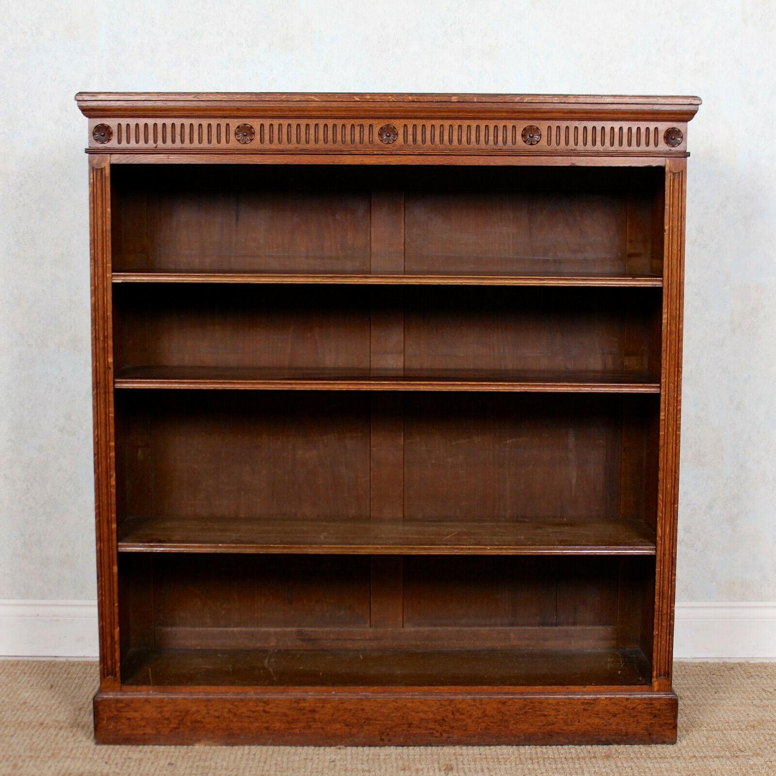 An impressive Edwardian open bookcase.
Constructed from solid oak boasting a well figured wild golden grain and rich patina.
The carved flowerhead and reeded frieze above adjustable shelving flanked by carved reeded columns and raised on a plinth