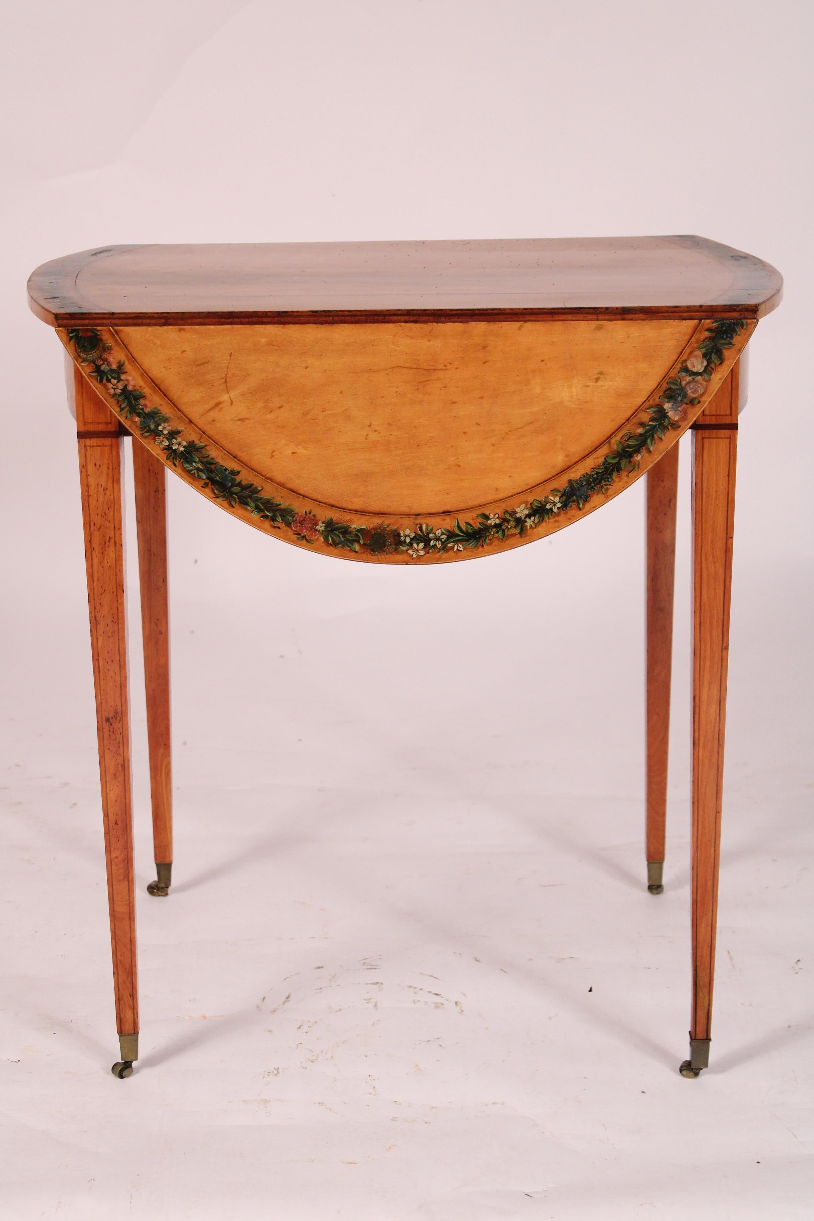 Table pembroke en bois satiné peint de style édouardien, vers 1890. Le plateau comporte deux feuilles en forme de D et des bordures extérieures peintes de motifs floraux, un seul tiroir, le tout reposant sur des pieds fuselés carrés terminés par des