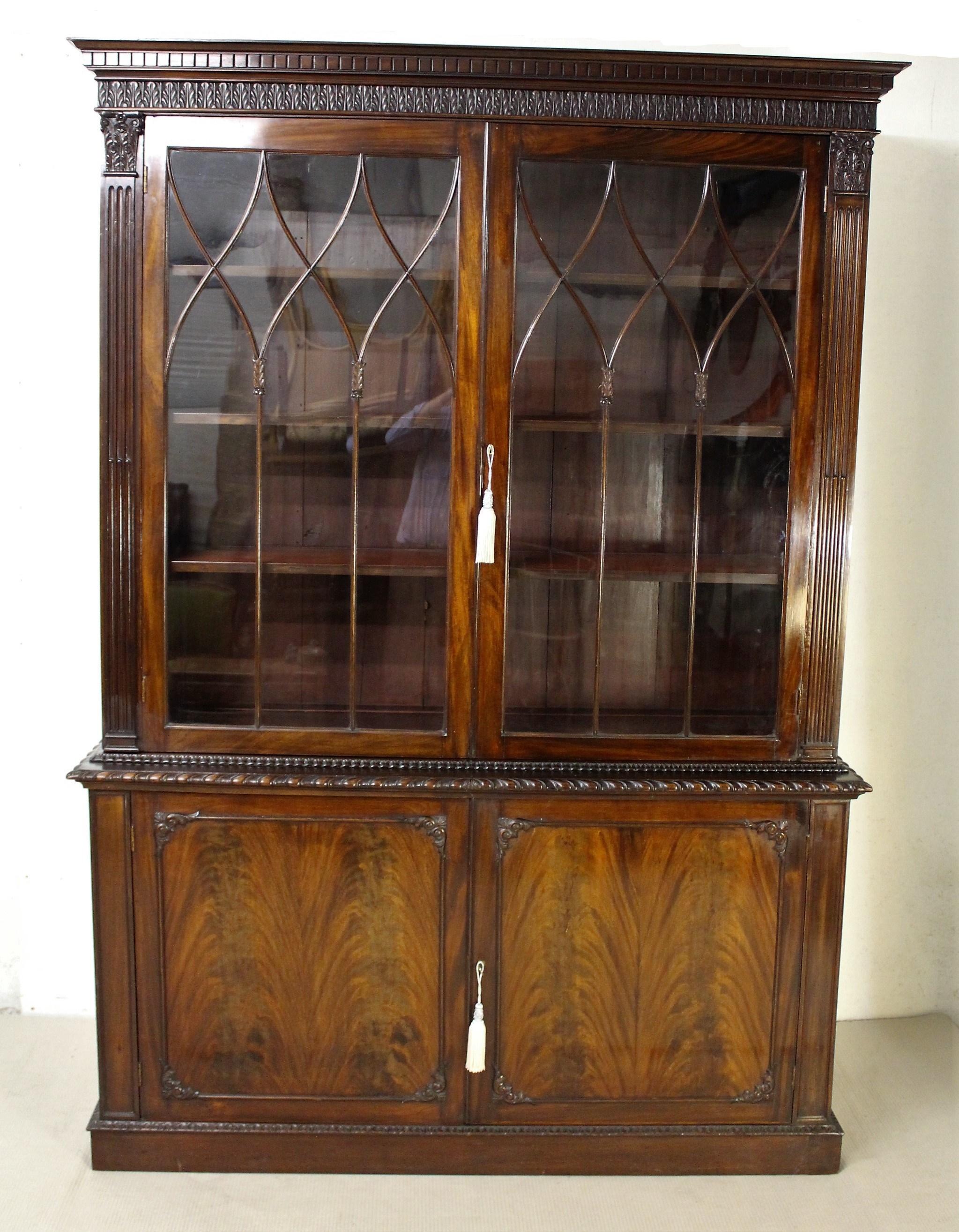 A splendid mahogany Chippendale style bookcase from the Edwardian period. Of fine construction and generous proportions. The top section with a pair of glazed doors flanked by Corinthian pilasters topped with capitals. The doors open to access the