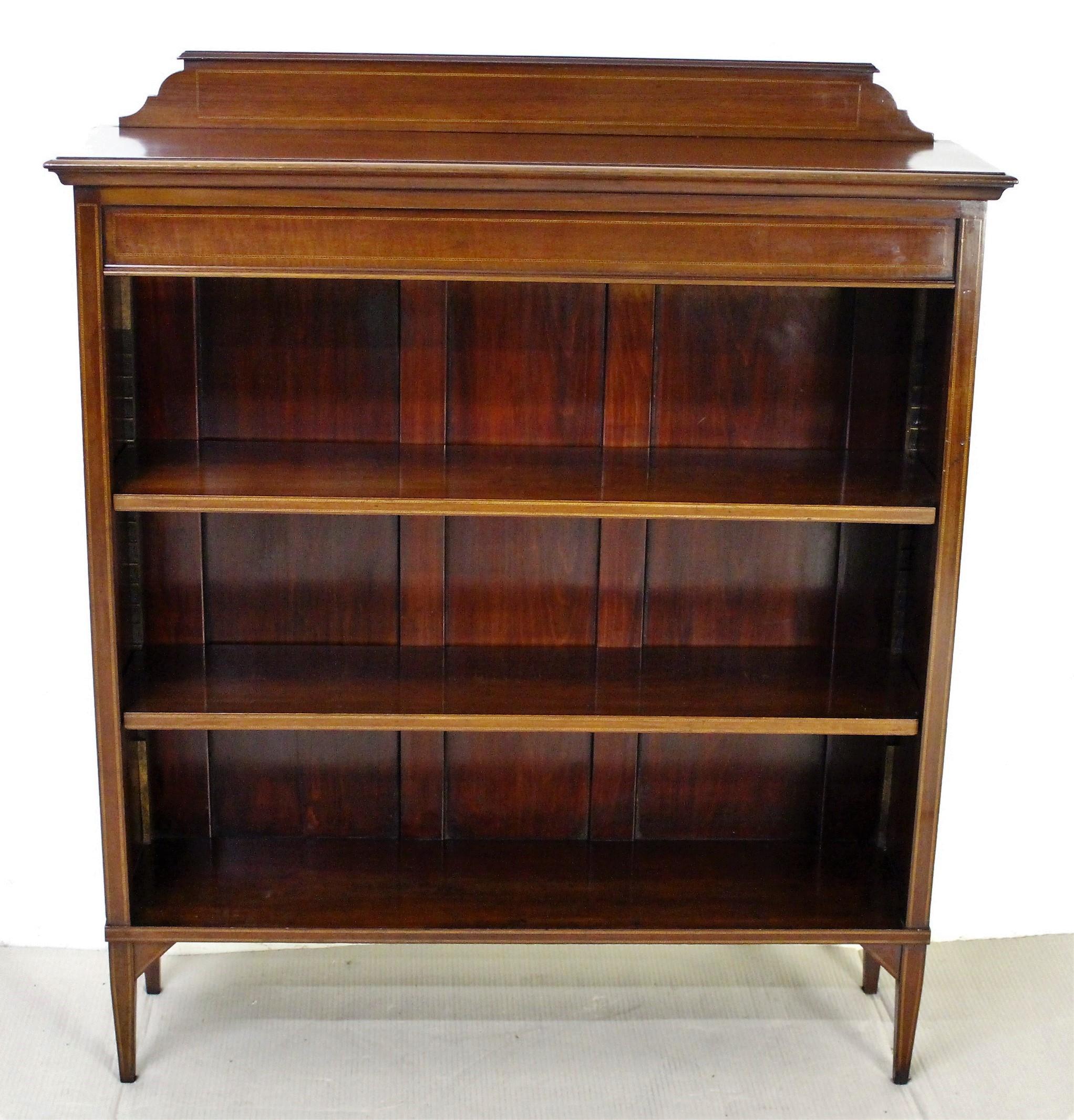 An excellent Edwardian period inlaid mahogany open bookcase. Well-constructed in solid mahogany and decorated with cross banding and chequer banding inlay in boxwood. The top with an up-stand and all standing on tapering legs. The display space