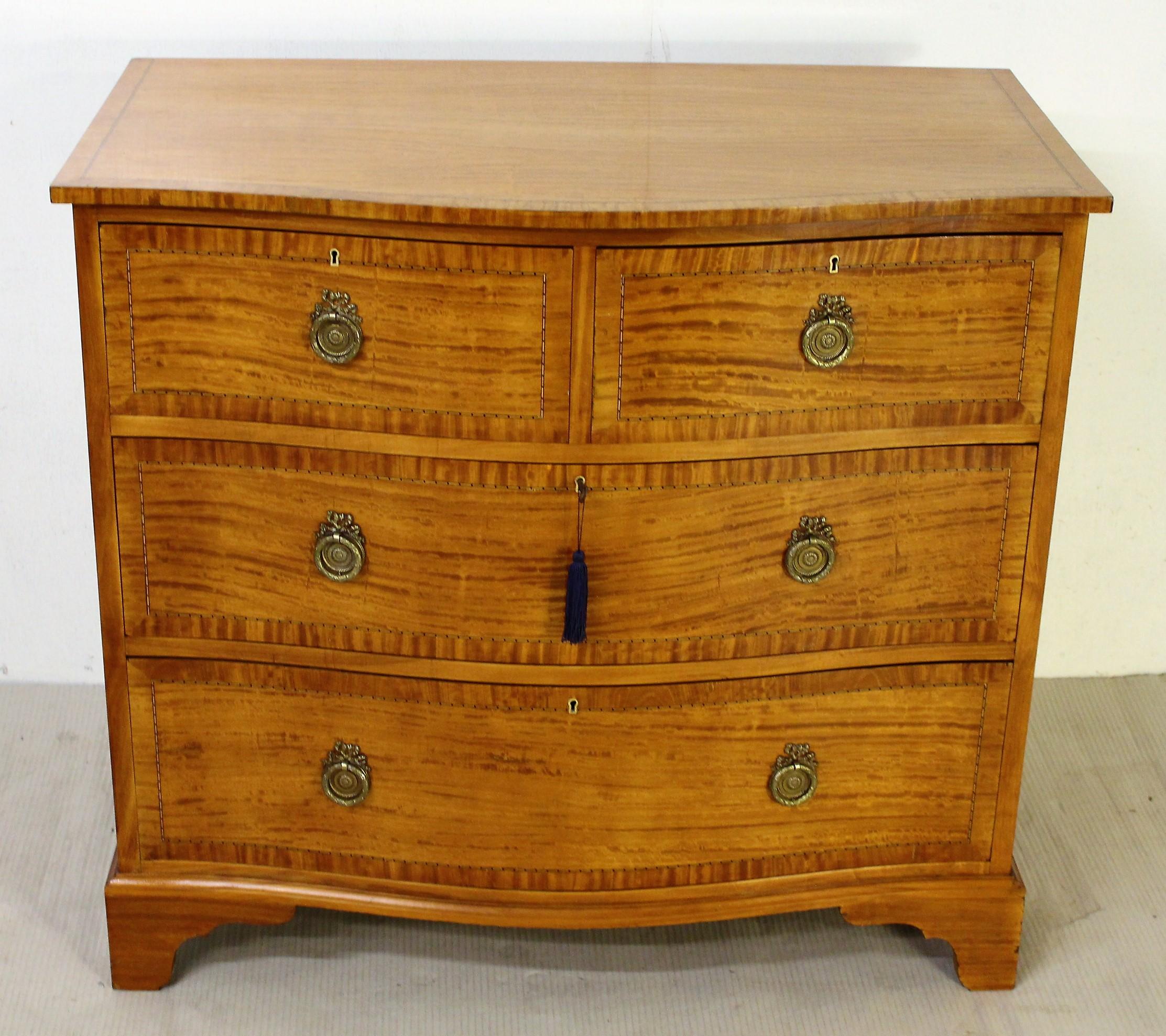 A fine quality Edwardian period inlaid satinwood chest of drawers. Of very good construction in solid satinwood and attractive satinwood veneers onto a mahogany carcas. Of gentle serpentine form and with a series of 2 short over 2 long drawers. The