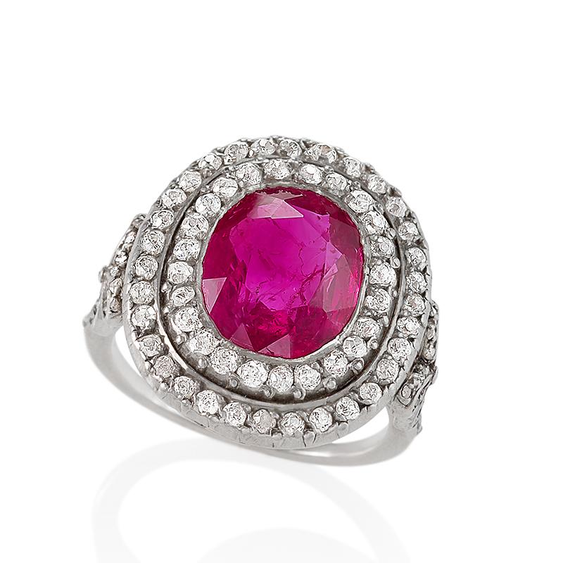 An Antique English Burmese ruby ring set in platinum and surrounded by 56 double rows of  round old European cut diamonds with the approximate total weight of .85 carats. The center oval-cut ruby weighs 5.26 carats. The ring is decorated with