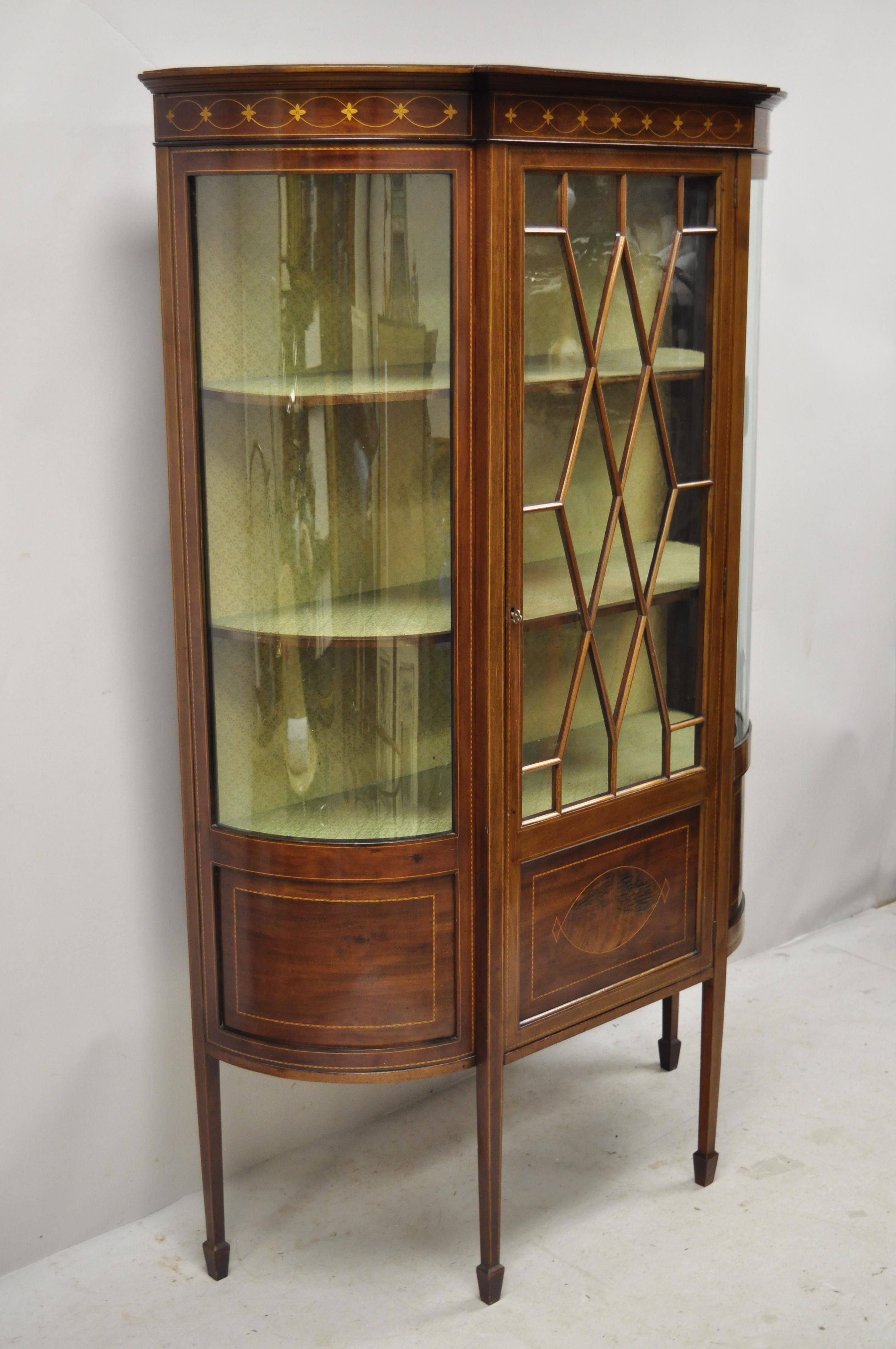 Antique English Edwardian satinwood inlay bowed curved glass China display cabinet curio. Item features satinwood inlay, curved glass sides, individual pieces of glass to front door, beautiful wood grain, 1 swing door, working lock and key, 2 wooden