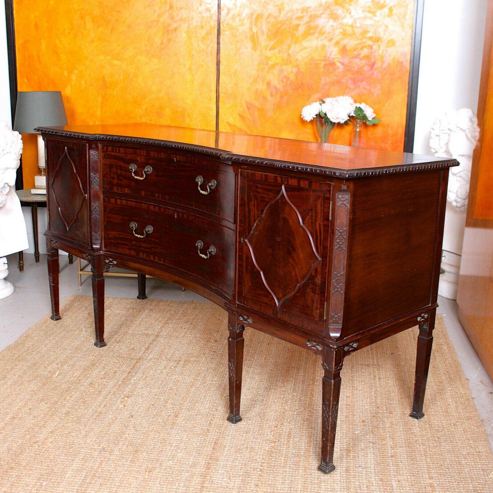 The Cuban mahogany boasting an impressive flamed grain and rich patina.
The top with intricately carved and moulded chamfered edges. The central concave form front drawers mounted with good handles, dovetailed jointing and clean interiors. Flanked