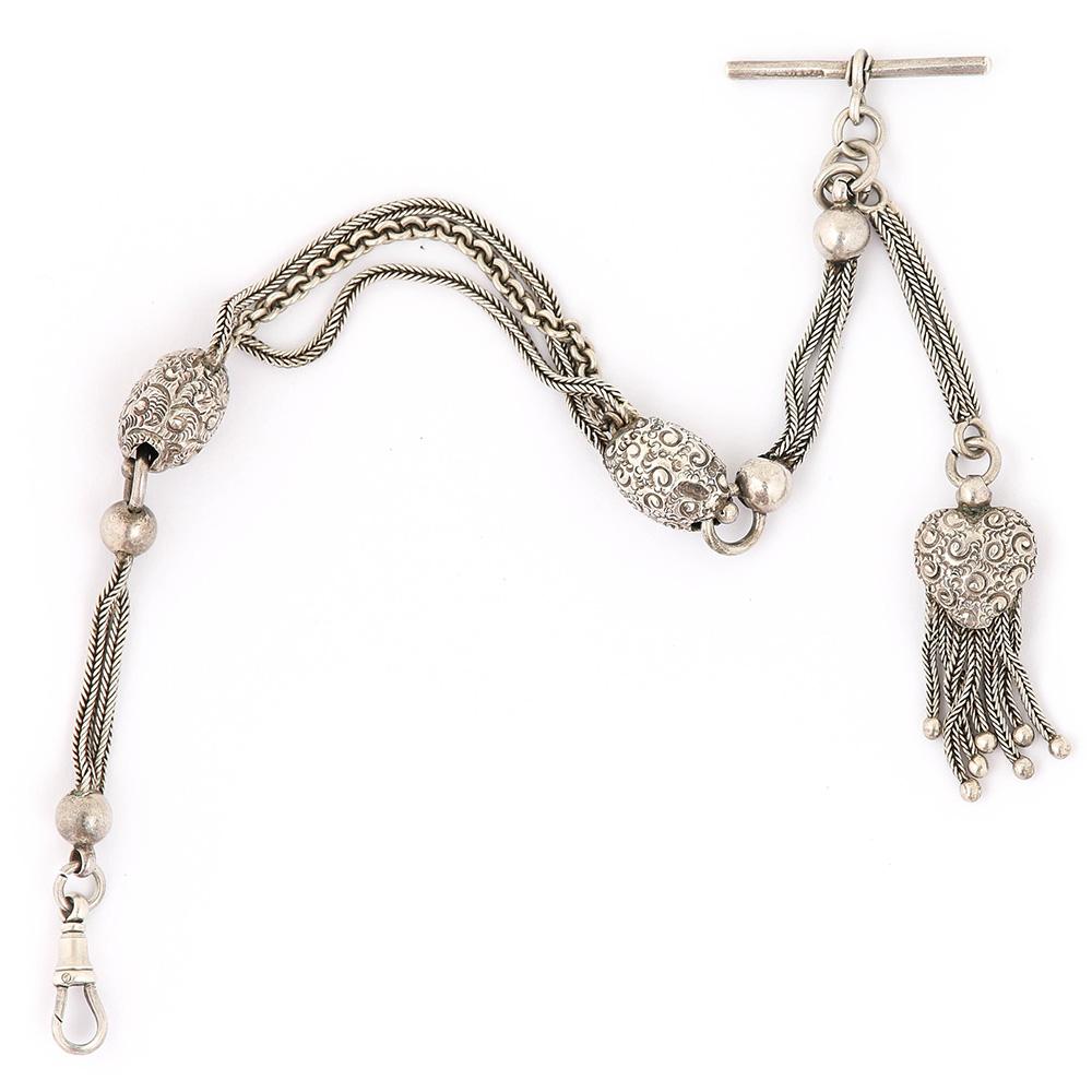 A charming silver antique albertina bracelet with two embossed silver egg shaped sections with a pretty heart tassel that hangs from the bracelet when worn by a lady. Connected by a foxtail link chain and a curb section, this pre-loved bracelet has