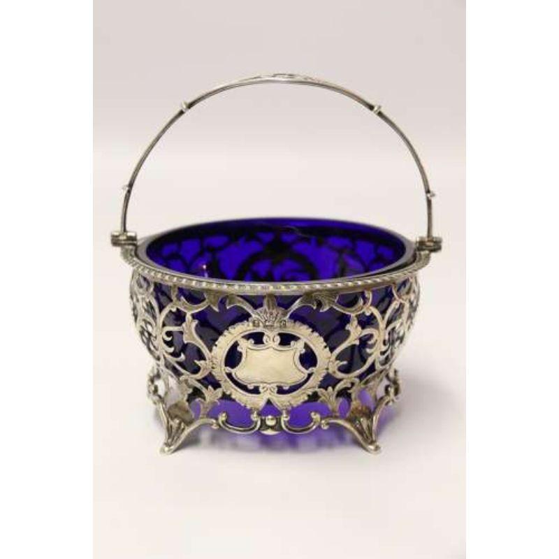 A fine English Edwardian silver sugar basket

This stylish and intricately made English Edwardian sugar basket is a fine piece of silversmithing. It was made in Birmingham 1902 1903. It is beautifully fretted and engraved with flowers and a folate