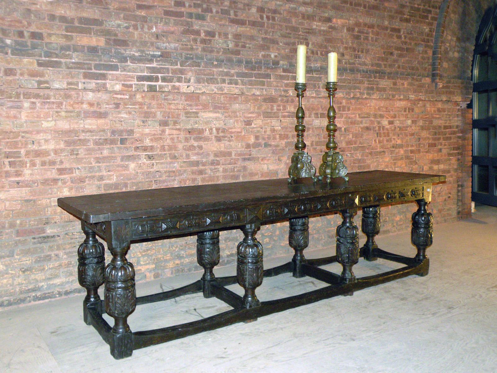 Spectacular long, rustic and very decorative Elizabethan Refectory table, well suited as console or library table or for casual dining. The rugged look with its worn down stretchers, the splits in the centuries old wood, the dark patina, beautifully
