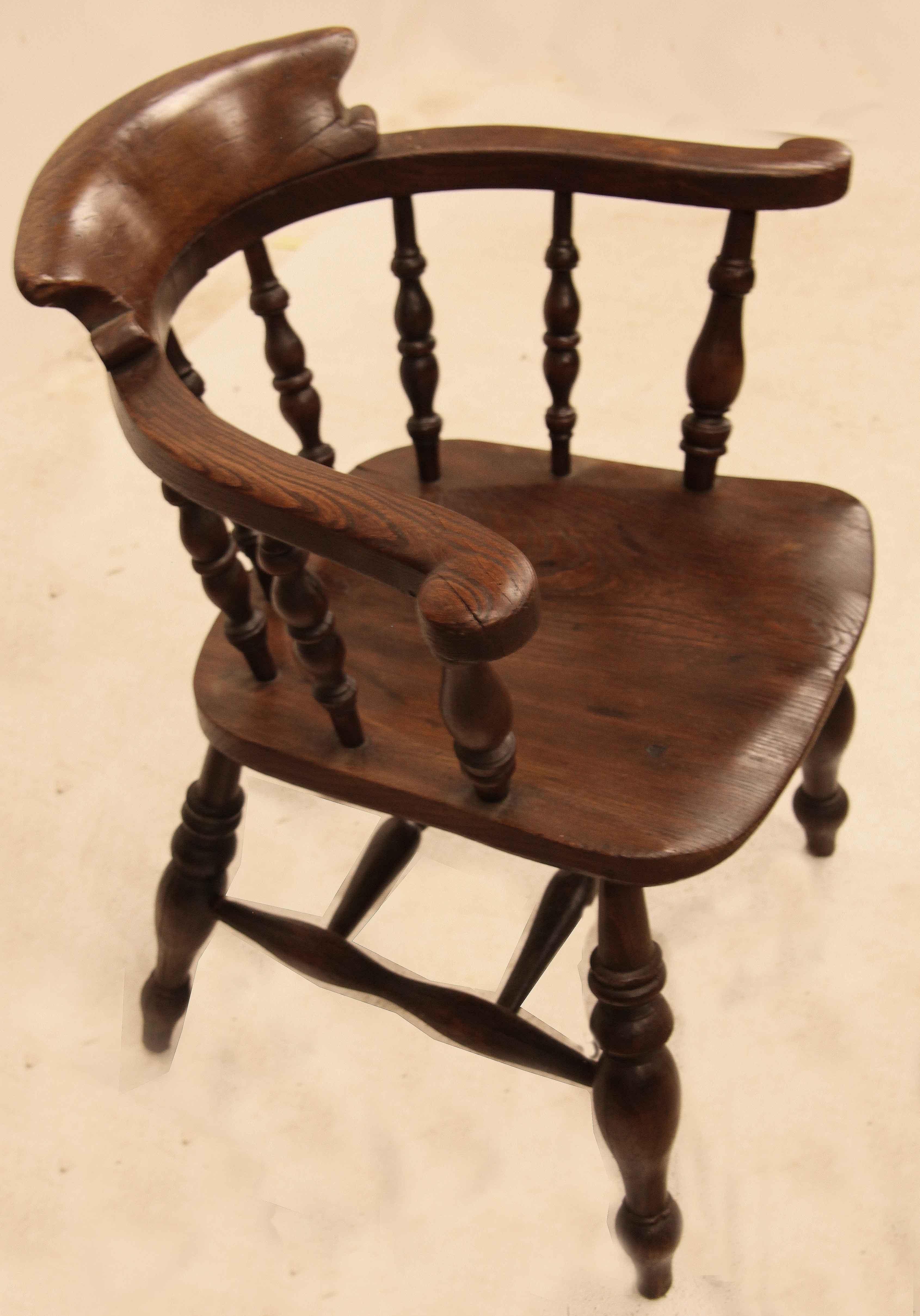 English elm captain's Windsor with warm color and patina, multiple spindles connect the arms to the shaped seat, legs with front to back stretchers and two cross stretchers for added stability.  Captain's Windsors are usually very comfortable and