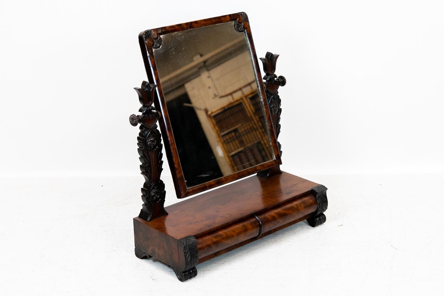 English Empire dressing mirror, has two bow front drawers in crotch mahogany with acanthus carved styles, original mirror. The feet are scrolled.