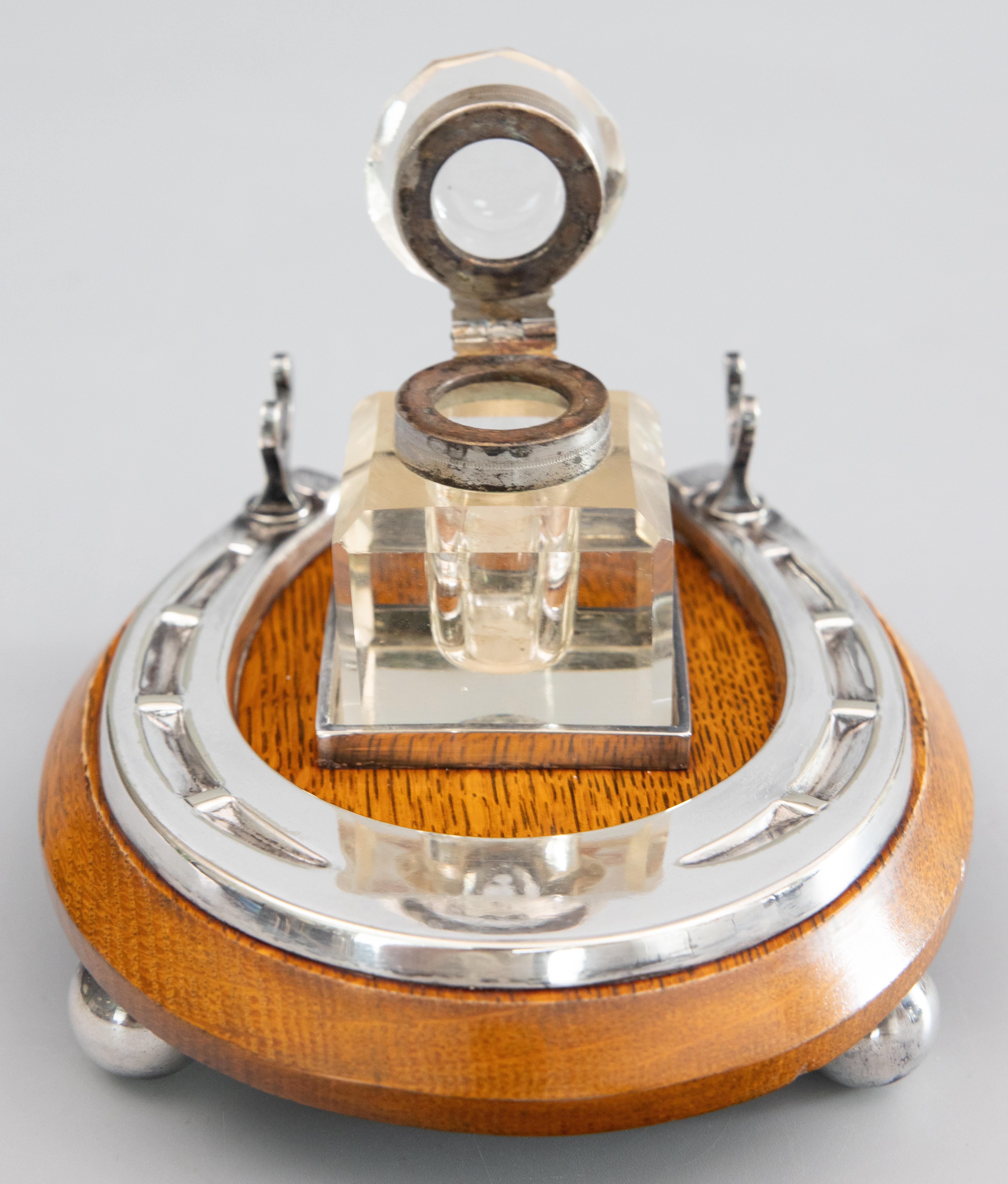 A superb antique English Edwardian silverplate and oak inkwell inkstand with a pen rest, circa 1900. This fine inkstand has the original lovely cut crystal inkwell surrounded by a silverplated horseshoe design on an oak base with charming silver