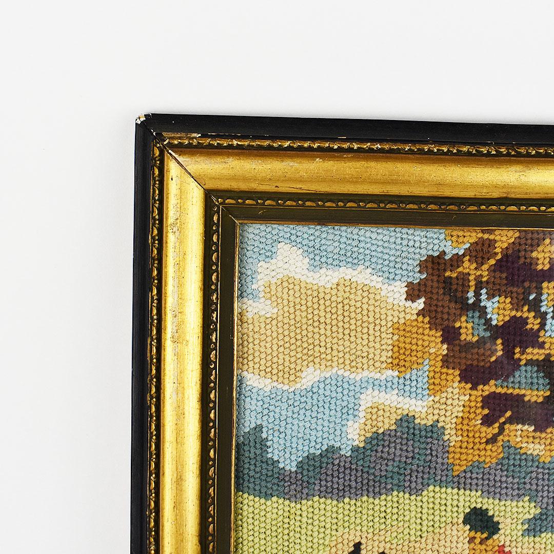 Tall hanging framed hunting scene in needlepoint. This piece is a beautiful classical English hunting scene handmade and created from needlepoint. The piece depicts a rider in a traditional red hunting coat on horseback riding through a field of