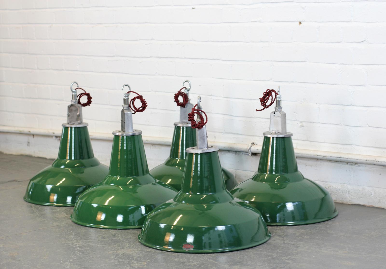 English factory lights by Thorlux, circa 1950s.

- Price is per shade (4 available)
- Vitreous green enamel shades 
- White enamel inner reflectors
- Comes with 100cm of red braided cable
- Takes E27 fitting bulbs
- Comes with steel suspension chain