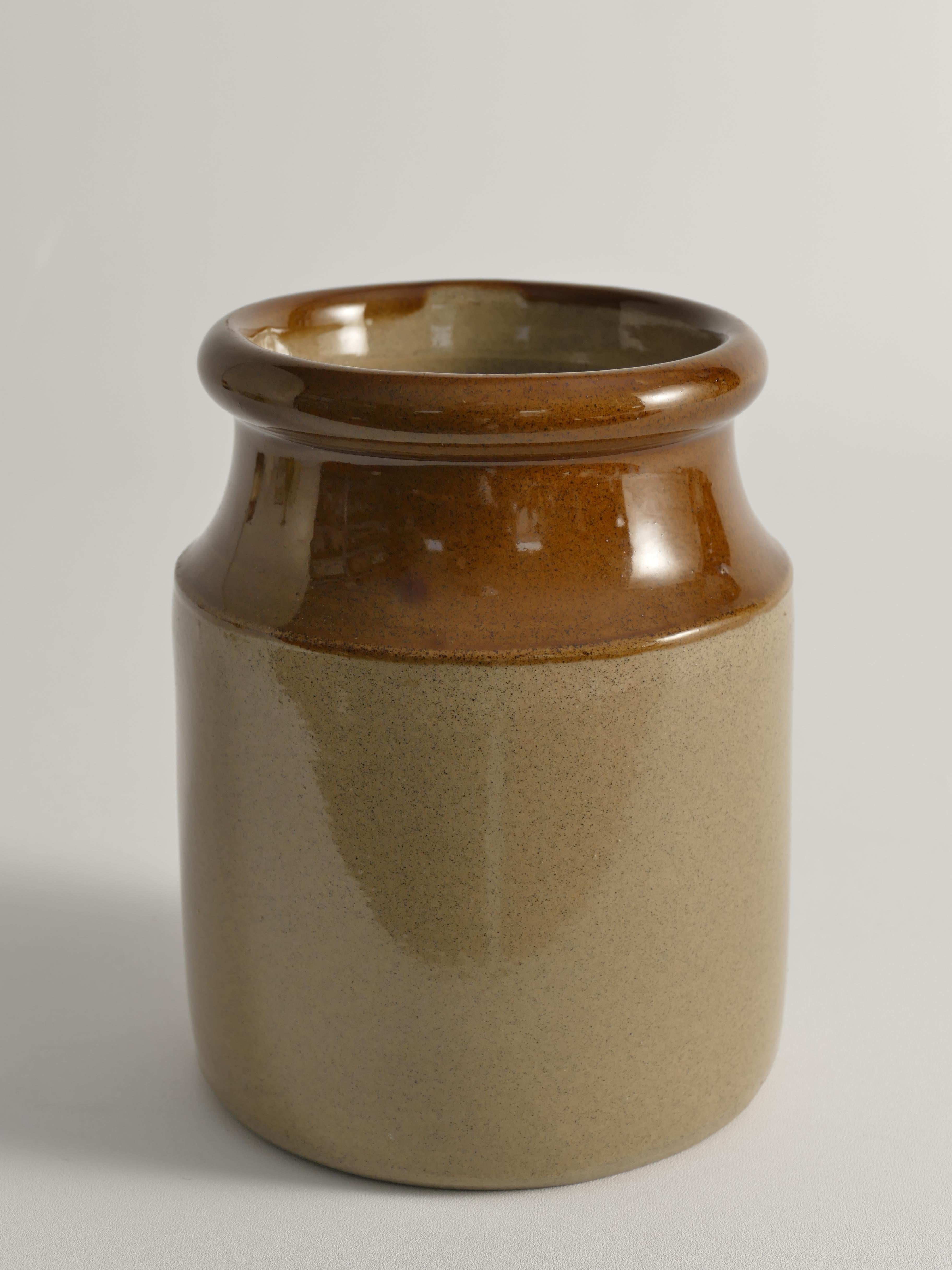 This two-tone Moira stoneware jar from England combines classic style with practical function. Featuring a traditional English design, it showcases earthy neutral tones that complement any decor. 

The jar's two-toned caramel and sand color glaze