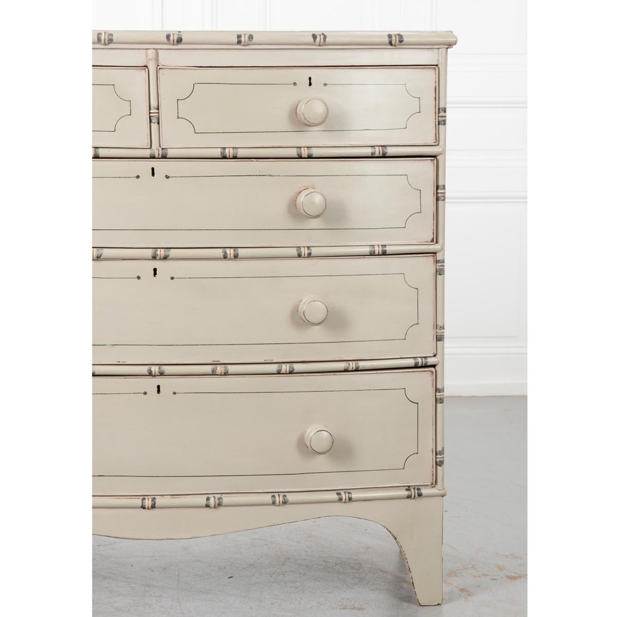 This is an English 19th Century pine chest recently painted in a layered cream finish with faux bamboo designs. It has two smaller drawers across the top and three wide and deep drawers beneath all with wood turned knobs. All the drawers are in