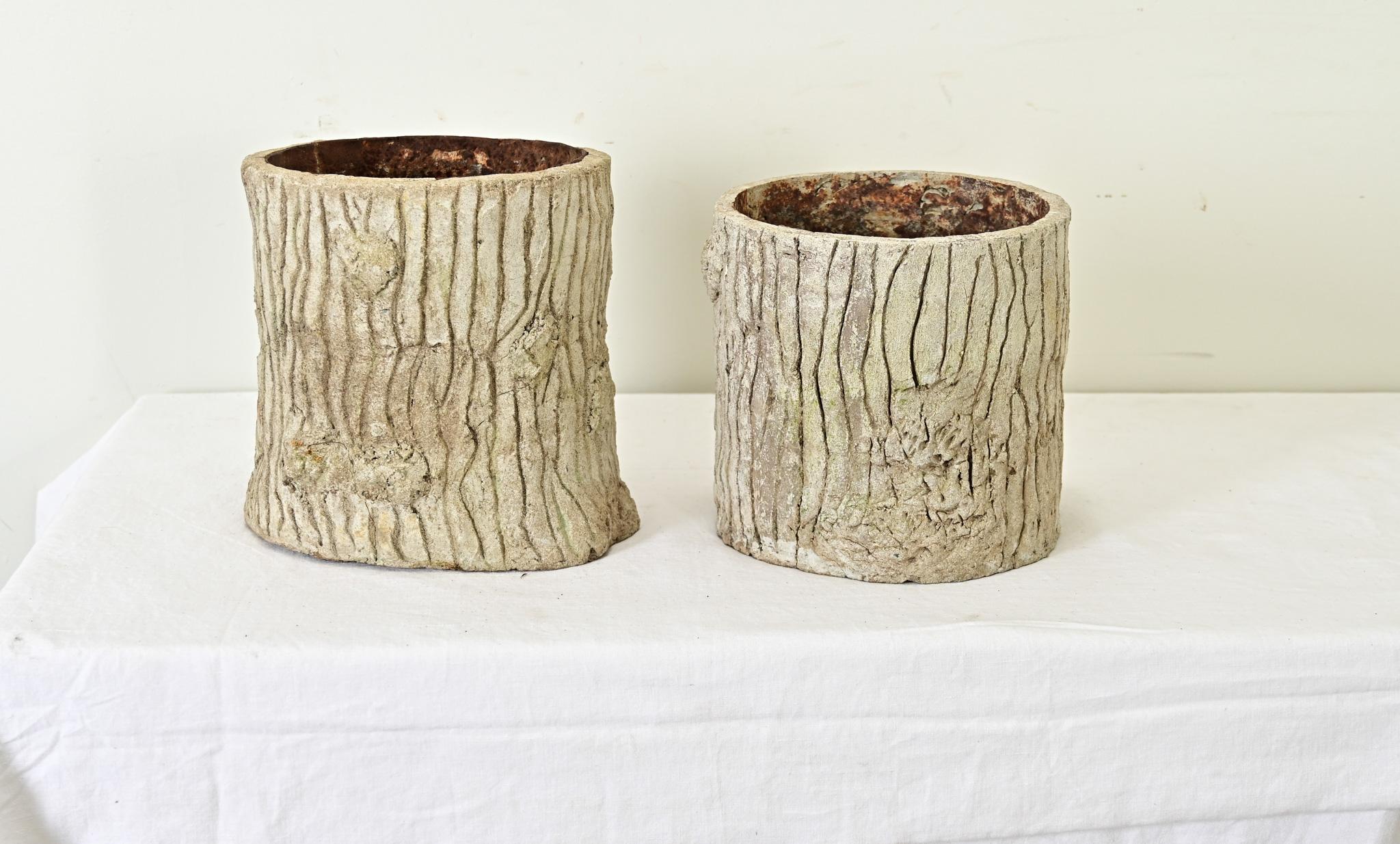 A whimsical pair of early 20th century English faux bois planters to add organic texture to any interior or patio. The reconstituted stone (a concrete mixture) has the familiar striations and wrinkles of tree bark under a patinated white exterior.