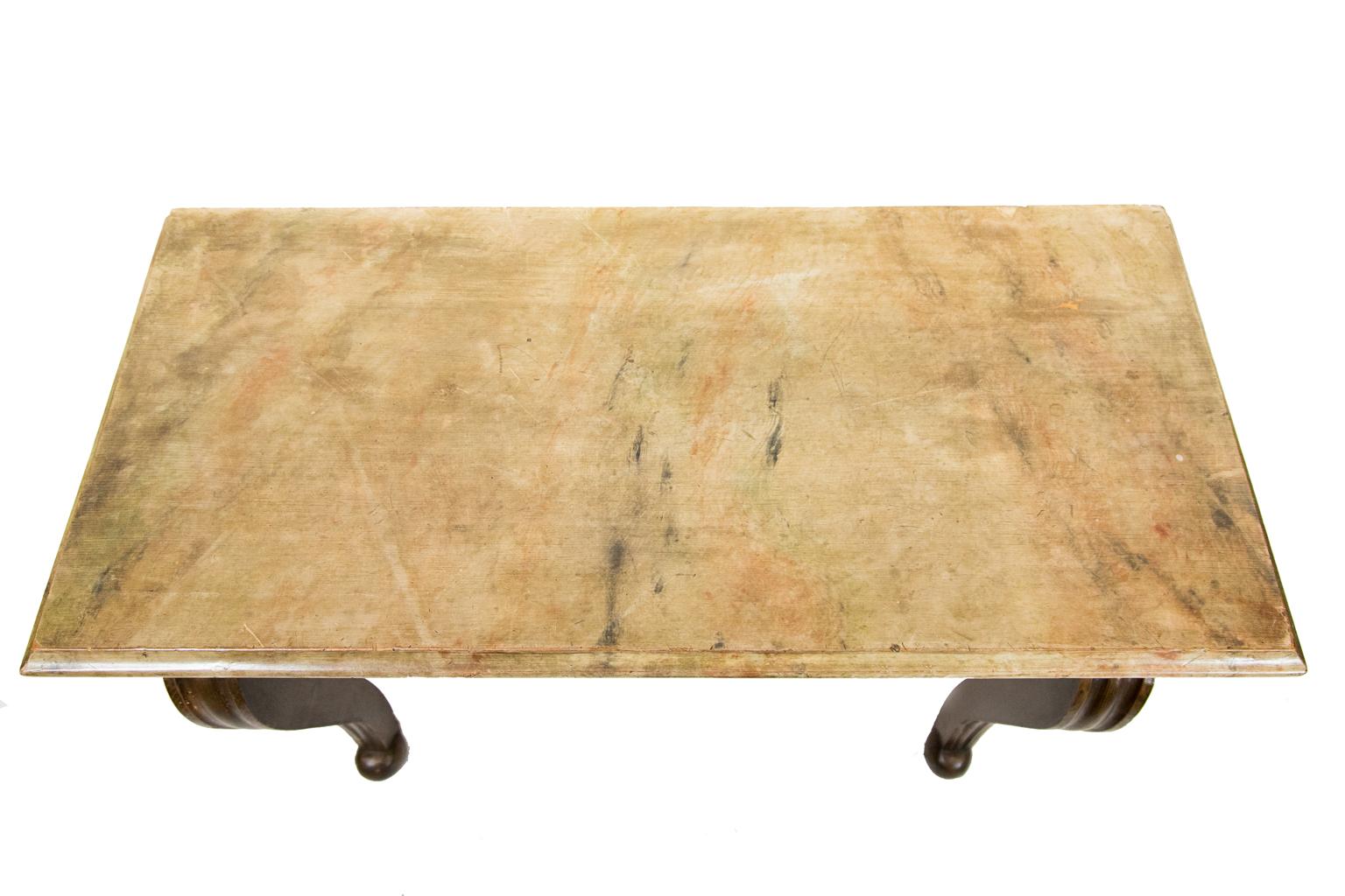 English faux painted console table, the top painted to simulate marble, while the base is painted to simulate wood. The table has a large heavy cast brass ornament in the front apron.
