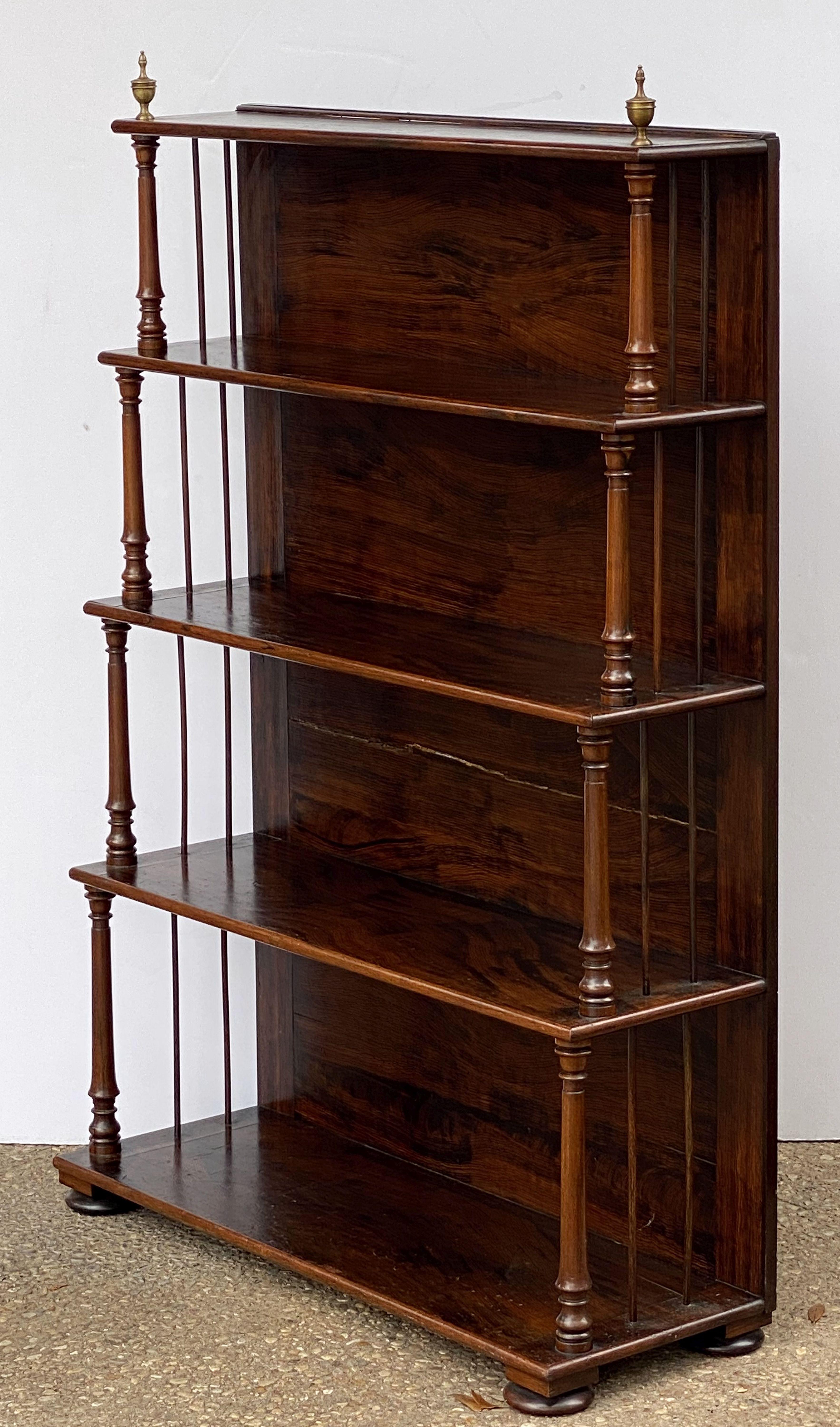 A fine English open bookcase or étagère of mahogany from the Edwardian era, featuring graduated shelves with a handsome faux wood grain finish, turned column supports, and decorative brass finials.

Dimensions: H 54 1/2 inches (top of finials) x W