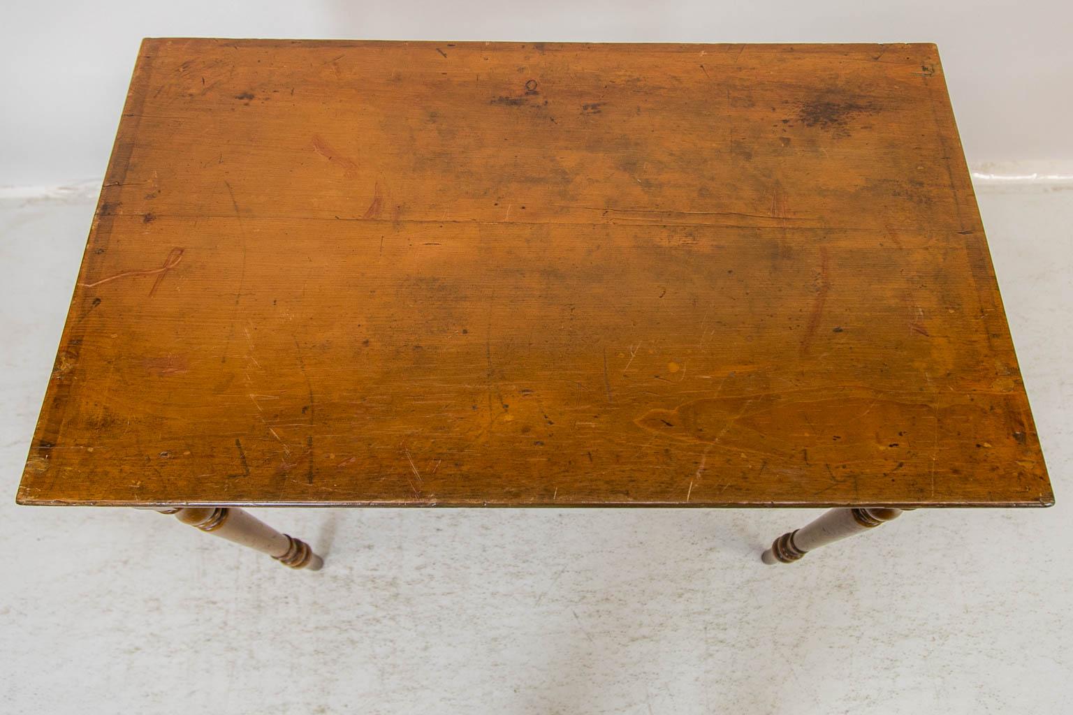 La base de cette table d'appoint est peinte pour simuler le bois et l'incrustation de lignes rouges. Le dessus présente quelques taches correspondant à l'usage et à l'âge. Les bords arrière et latéraux du plateau présentent une marque fantôme d'une