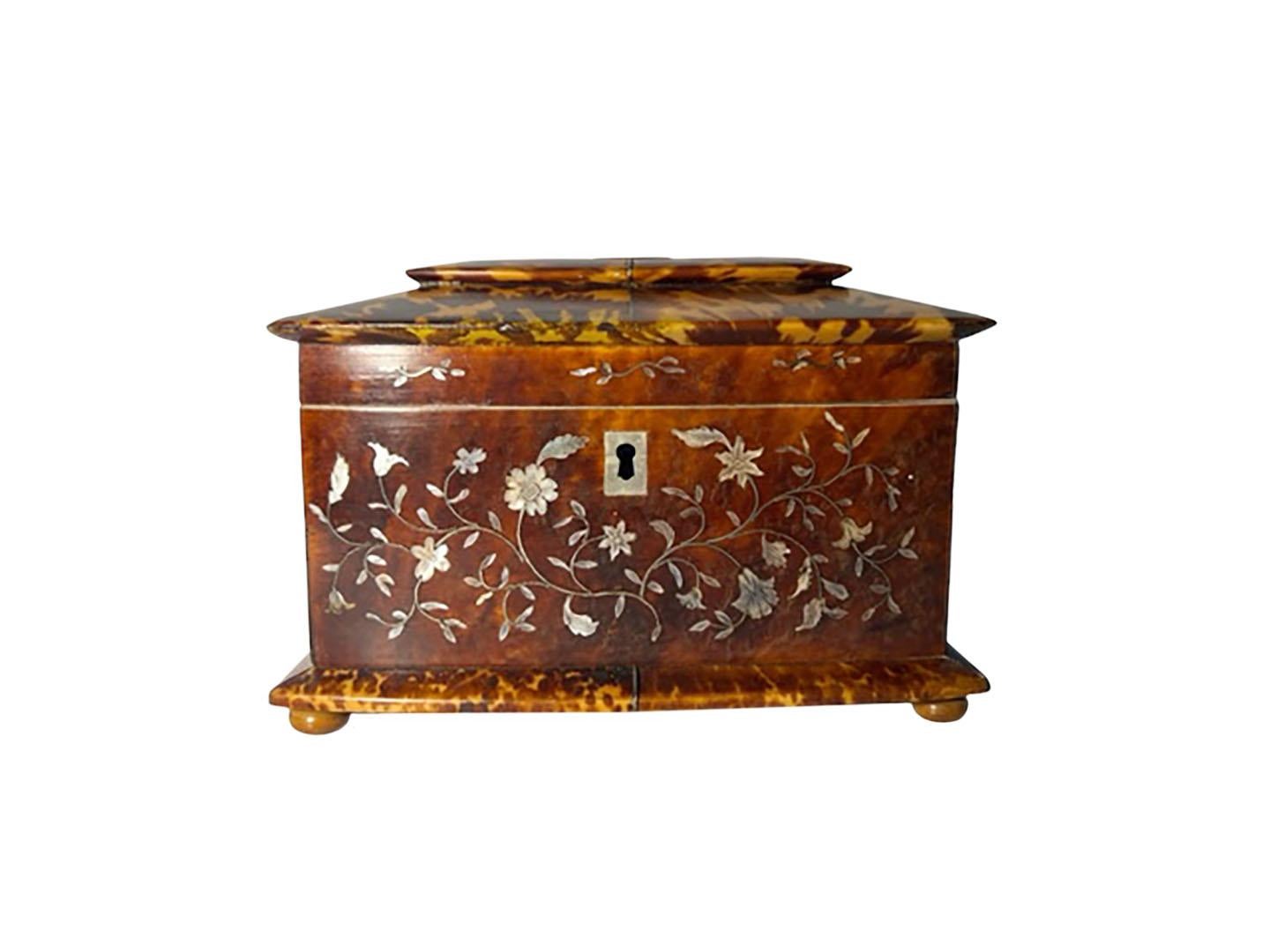 A lovely bow front tortoiseshell tea caddy inlaid with mother of pearl flowers and topped with a silver badge. English, circa 1870.