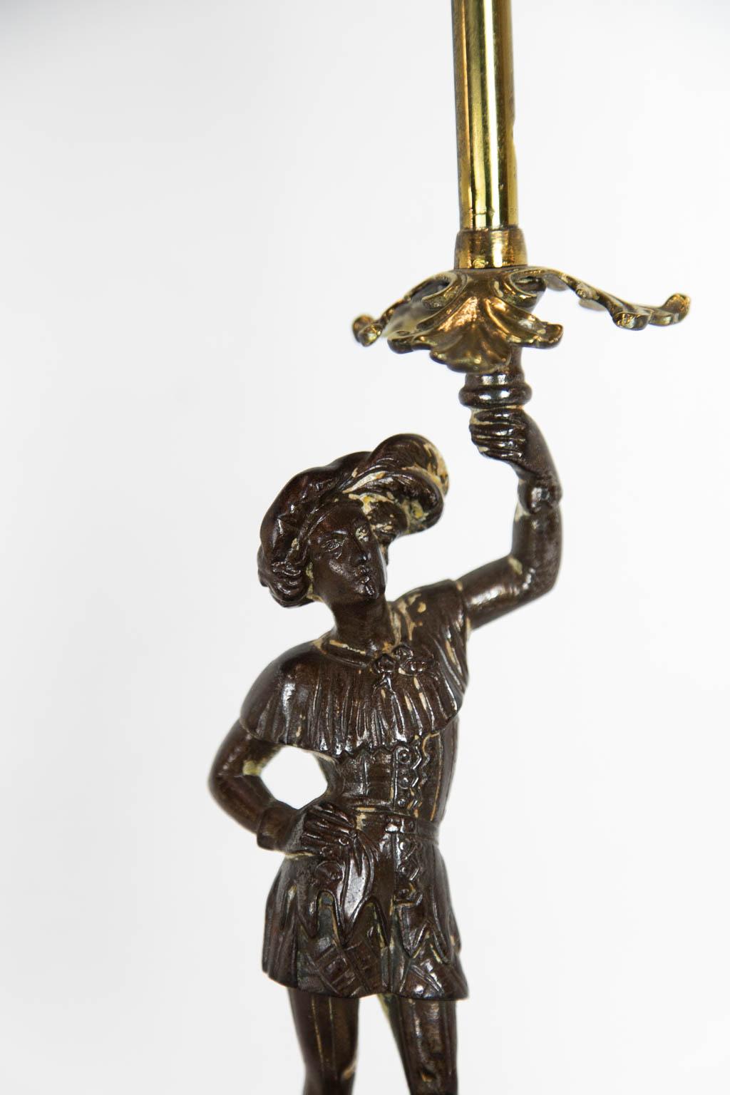 This lamp has a molded wooden base with a steel and brass figure of a cavalier.