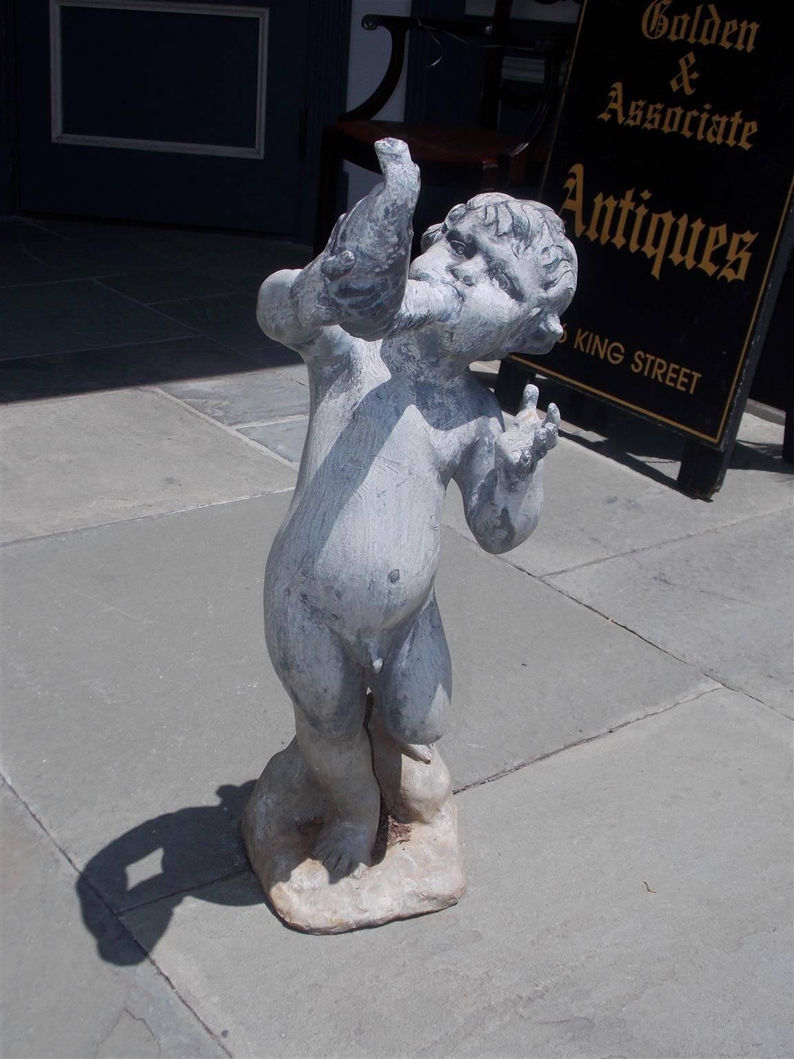 English figural lead fountain with a young man blowing a conch shell while standing on a rocky plinth. Fountain is in working condition, Mid-19th century.
