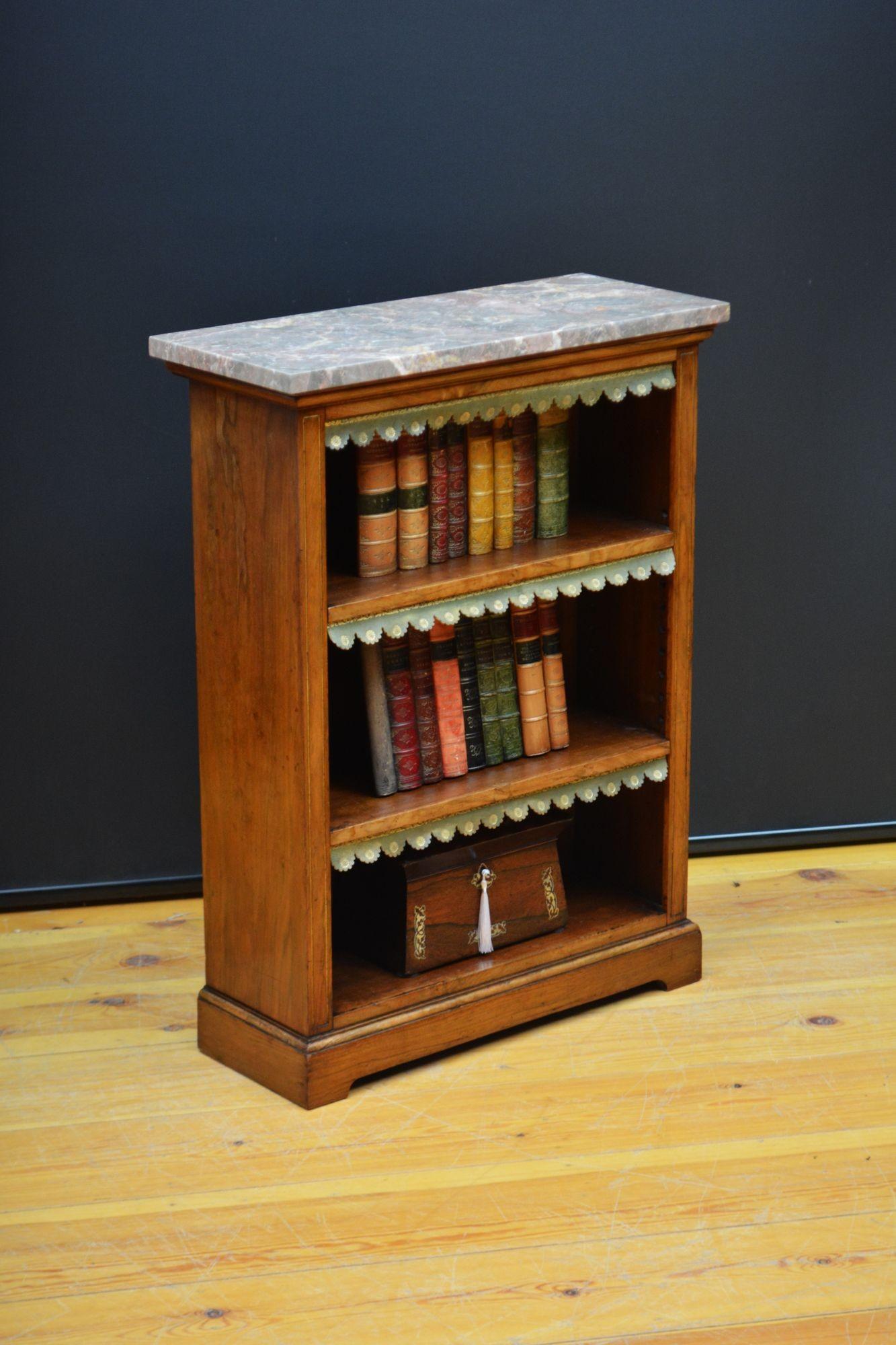 K0630 A low Victorian marble topped open  bookcase, having original veined marble above a shallow frieze and two height adjustable shelves all fitted with green tooled leather dust covers, flanked by fluted uprights with gilt decoration, all raised