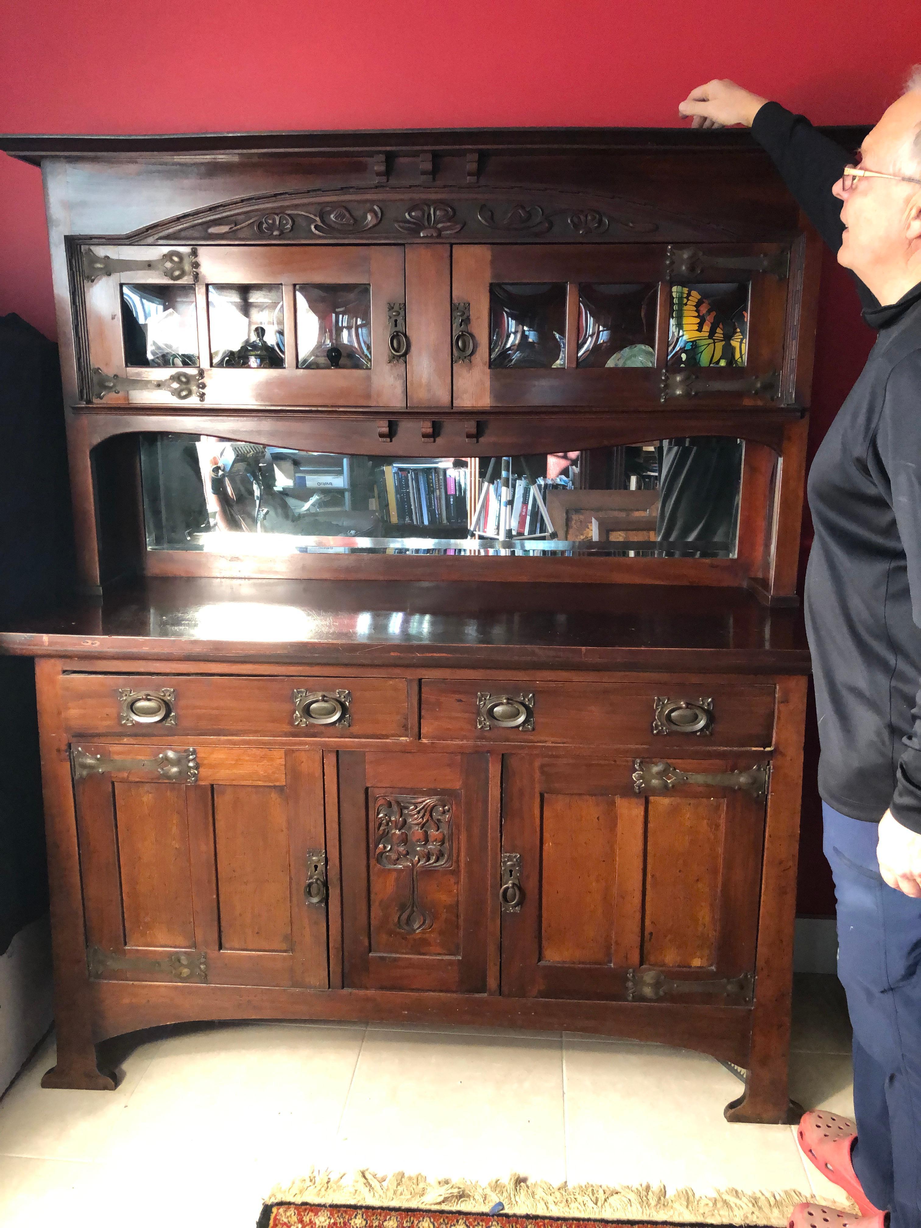 A fine English antique two part mahogany side board, buffet, or cabinet constructed in two parts, top and bottom. Features original Arts & Crafts tulip strap hinges and pulls hardware with 2 over 2 doors in the bottom section and 2 doors in top