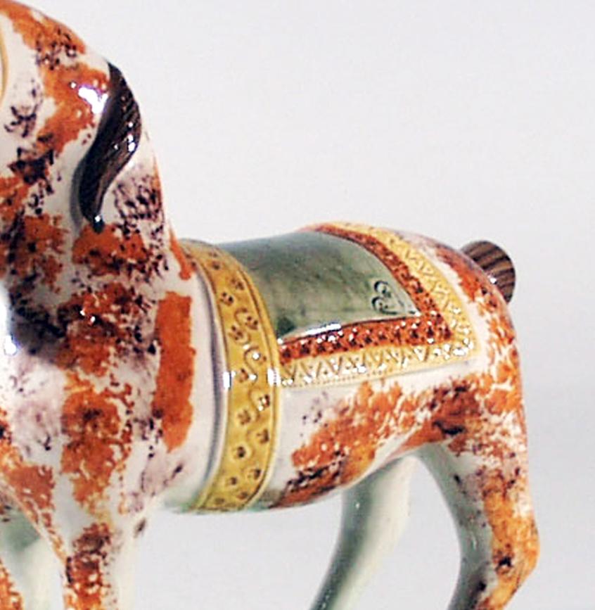 English finely colored pearlware horse, 
St Anthony, Newcastle,
circa 1825.

The horse, beautifully colored in brown and ochre blotches, stands on a green canted rectangular flat base with ears pricked and a docked tail, splashed in manganese