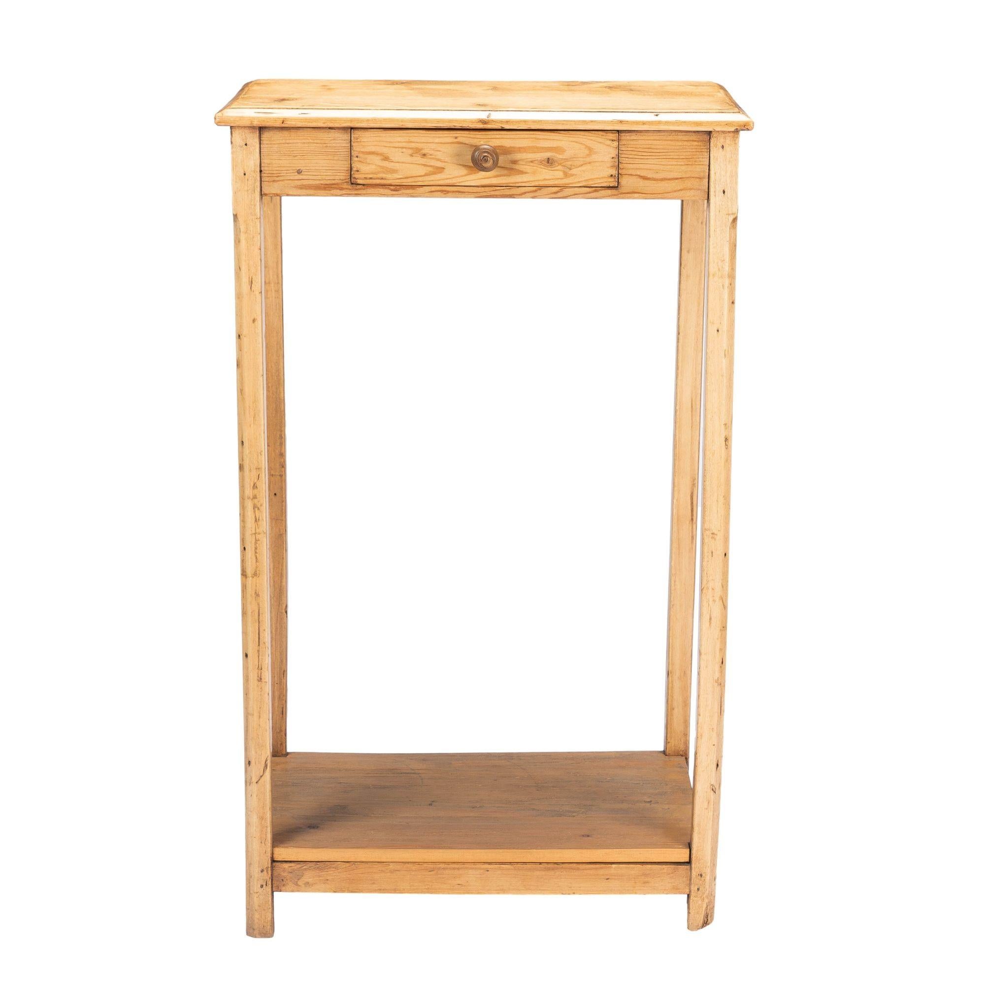 Unfinished English fir writing stand or clerks table. The table features an apron drawer with turned hardwood knob and square chamfered legs joined by a box stretcher. The shelf fitted to the box stretcher is a later addition. Legs have been leveled