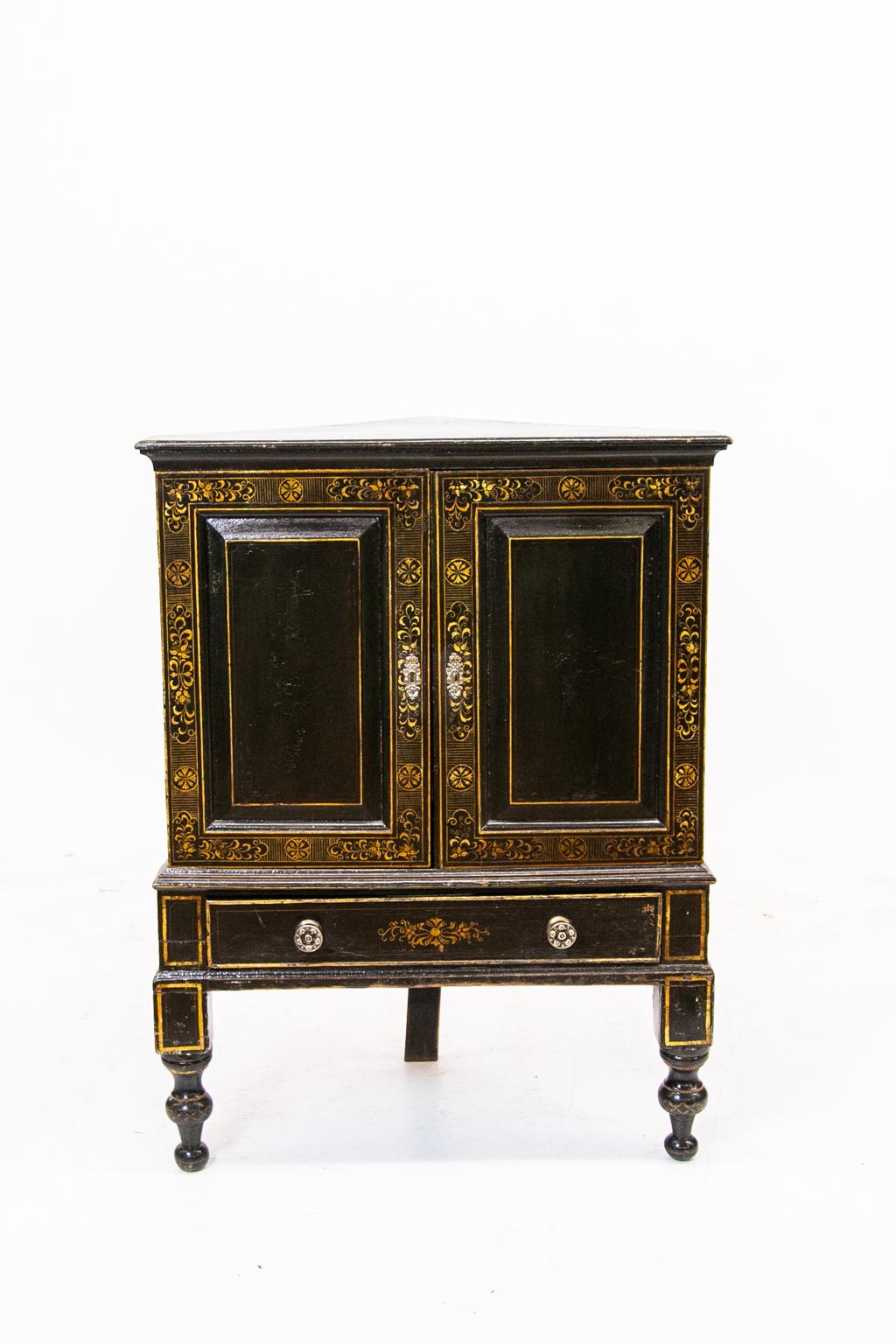 English fitted pine lacquer corner chest with eighteen interior cork lined drawers, lower single drawer, raised panel doors with floral lacquer borders and painted line inlay, on turned feet.
 