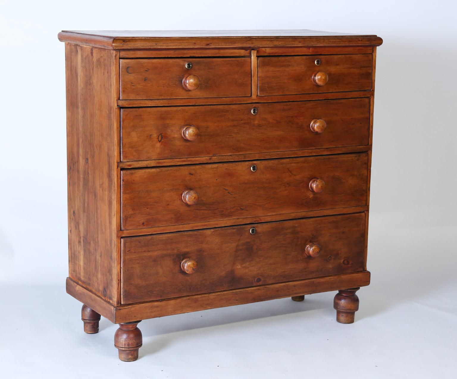 This beautiful English chest of drawers will suit many of your storage needs. The chest is constructed with the classic two over three drawers with simple round knobs and brass key holes. All of the drawers have an iron locking mechanism although no